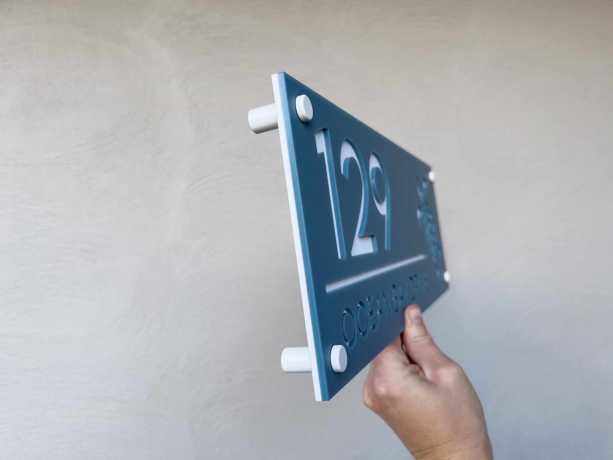 Hand holding the Honu sea turtle address sign side view