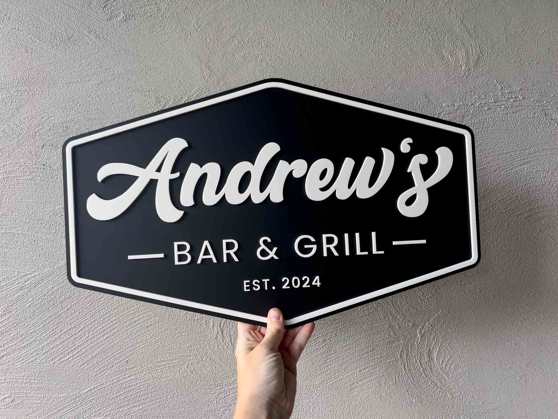 American retro badge style custom acrylic sign in black and white that says 'Andrew's Bar & Grill'.