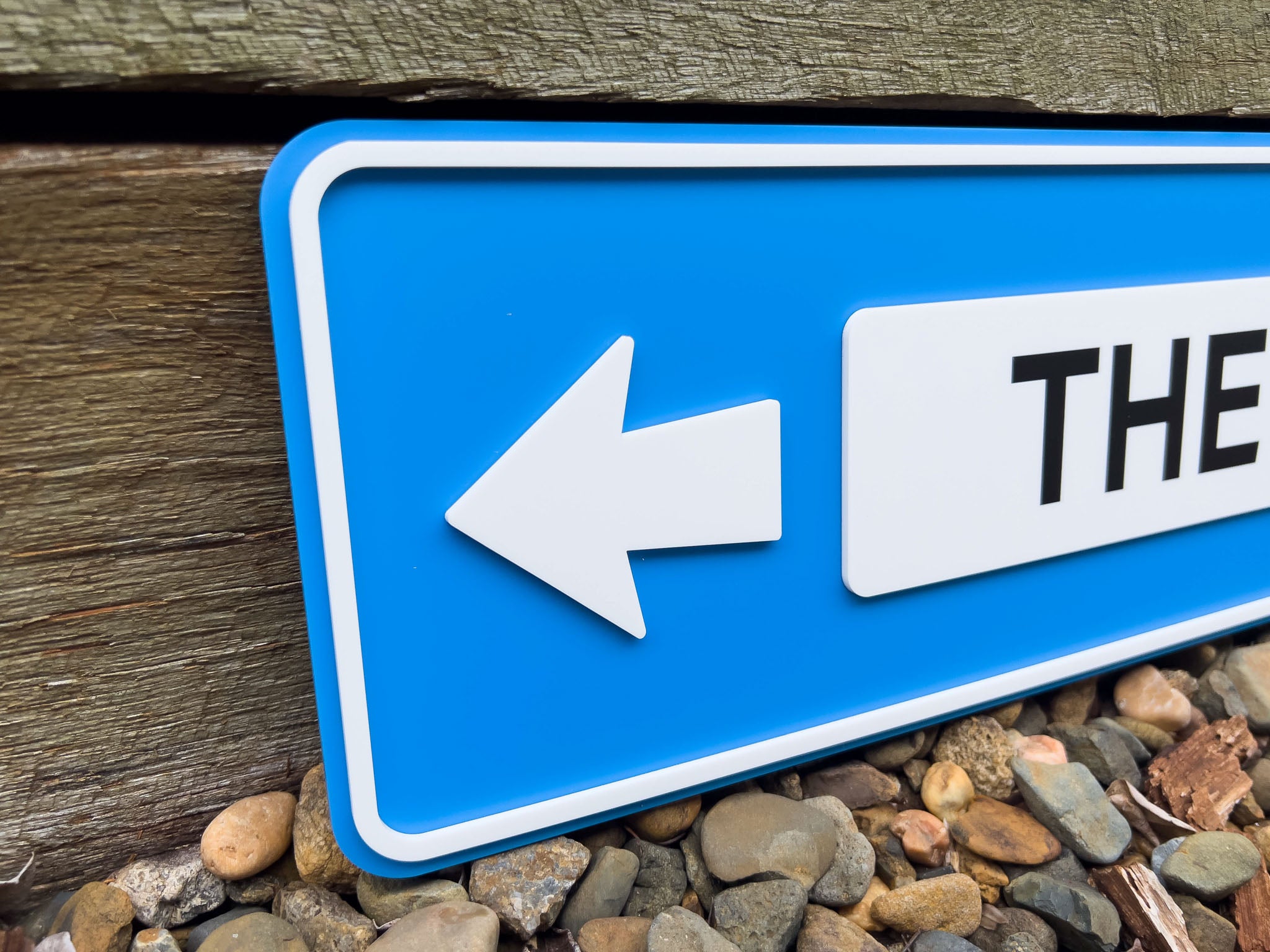 A close up of a 3D acrylic street sign in blue and white.