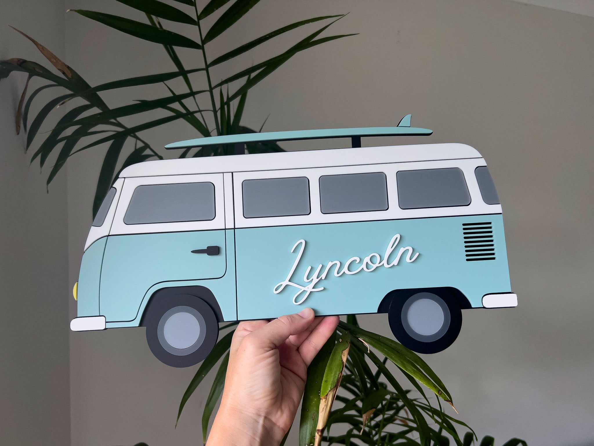 Hand crafted acrylic surf van with the name 'Lincoln', against a neutral background.