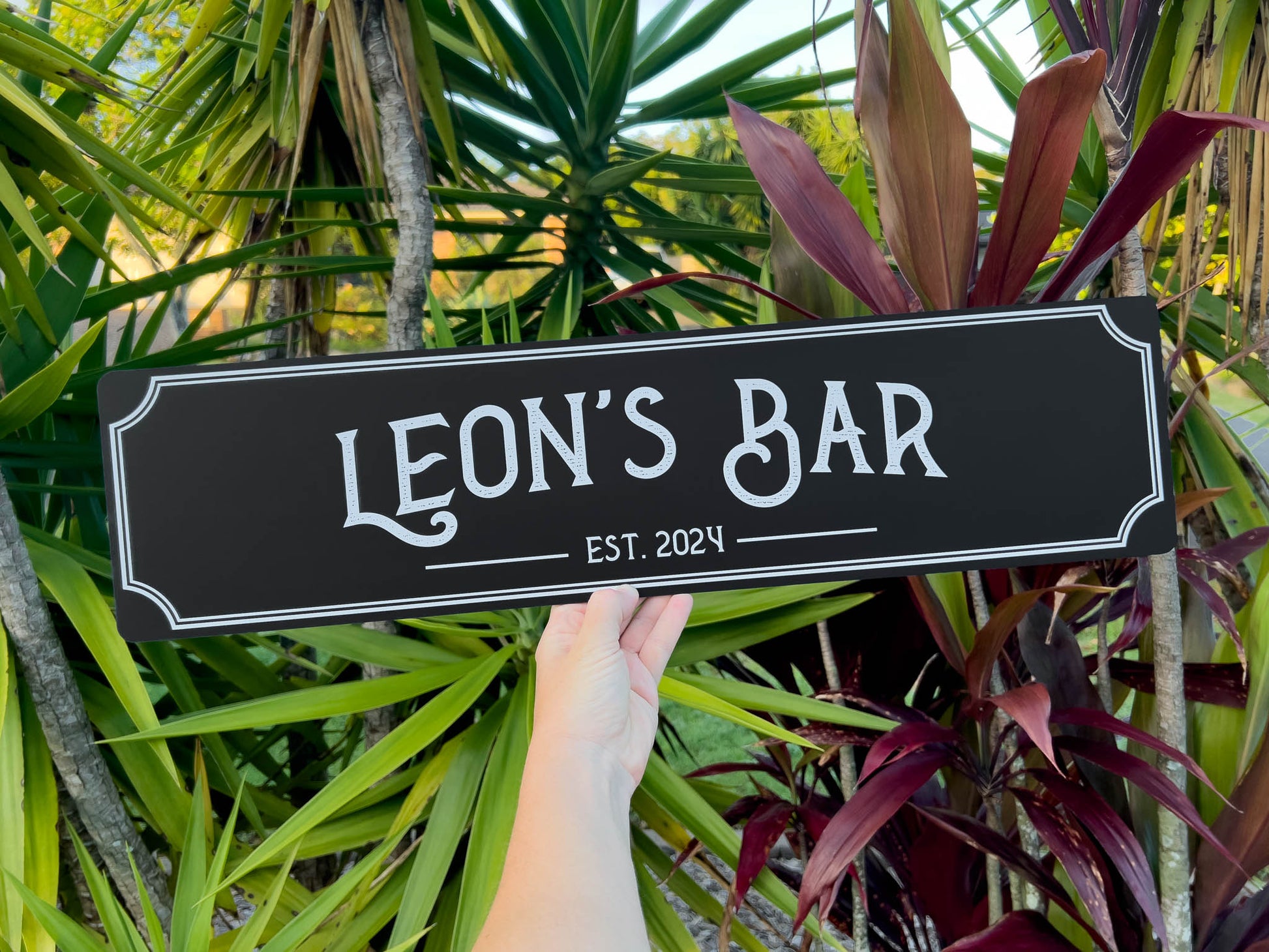 Custom printed vintage style textured print bar sign that says 'Leon's Bar' in black and white.