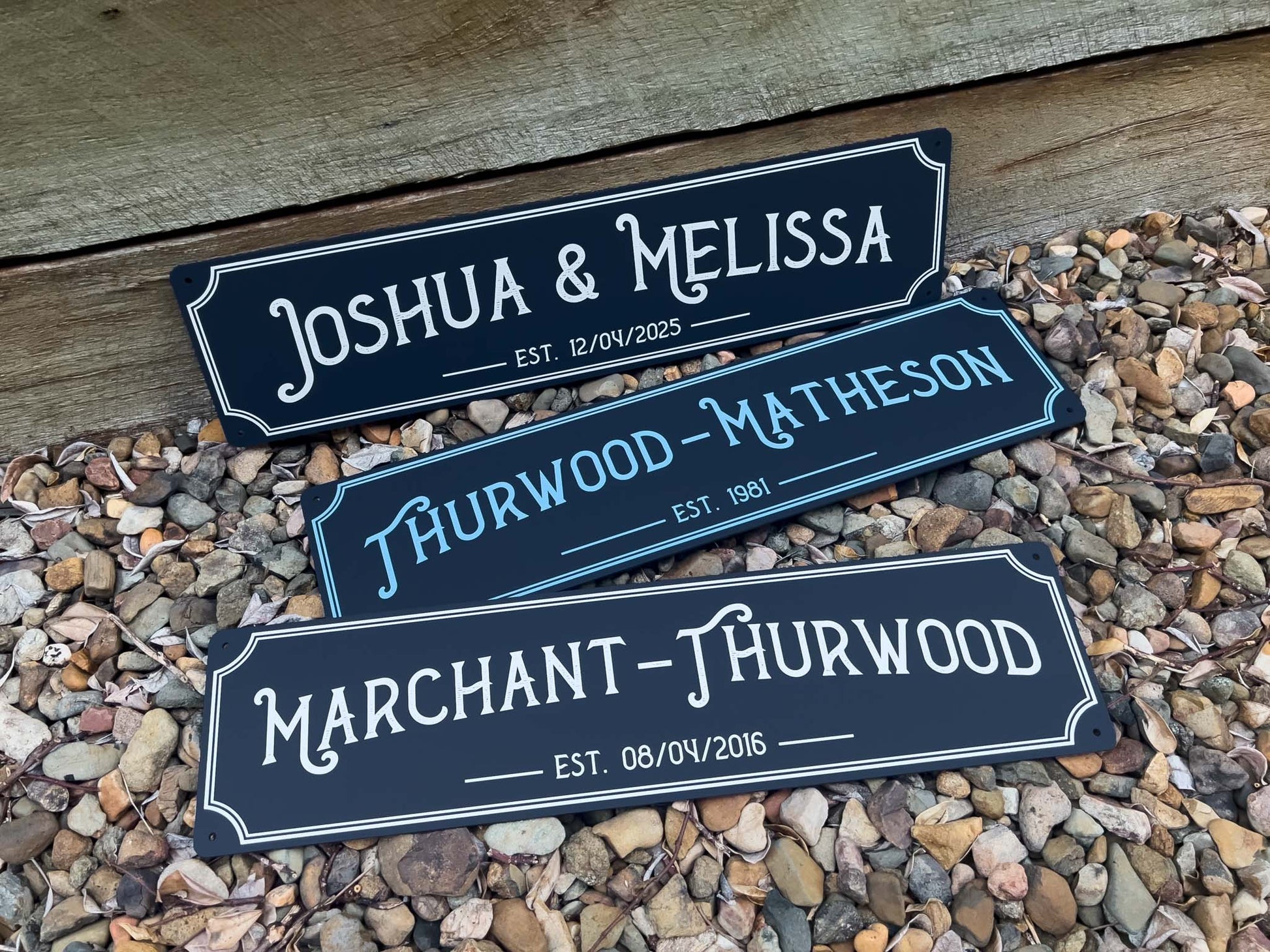 Three custom printed saloon style bar signs with names printed in a deep blue colour with white text.