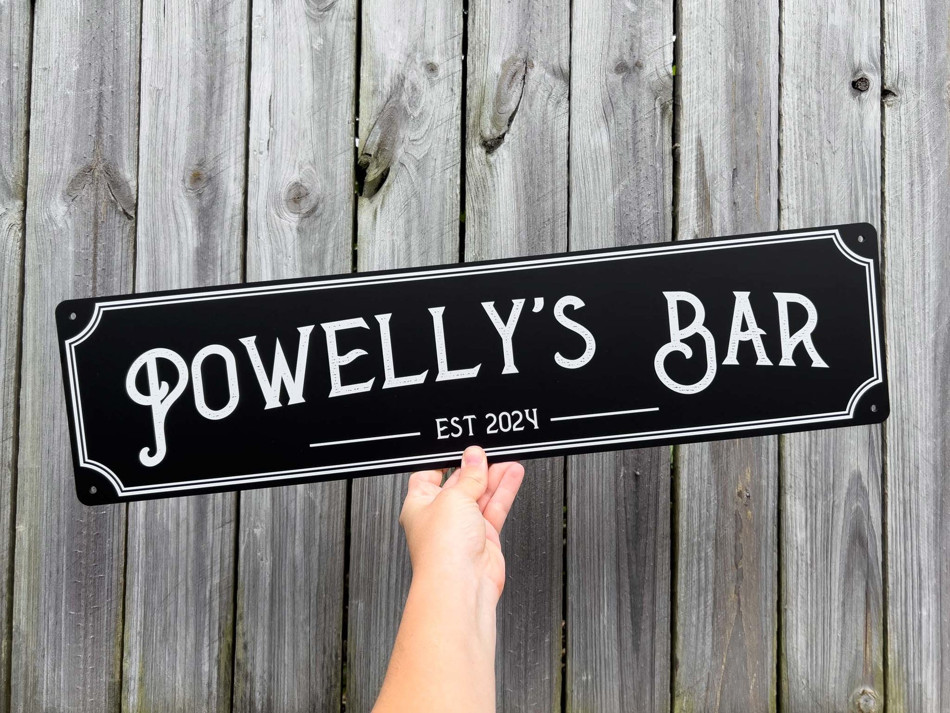Personalised printed black and white panel that says 'Powelly's Bar Est 2024'.