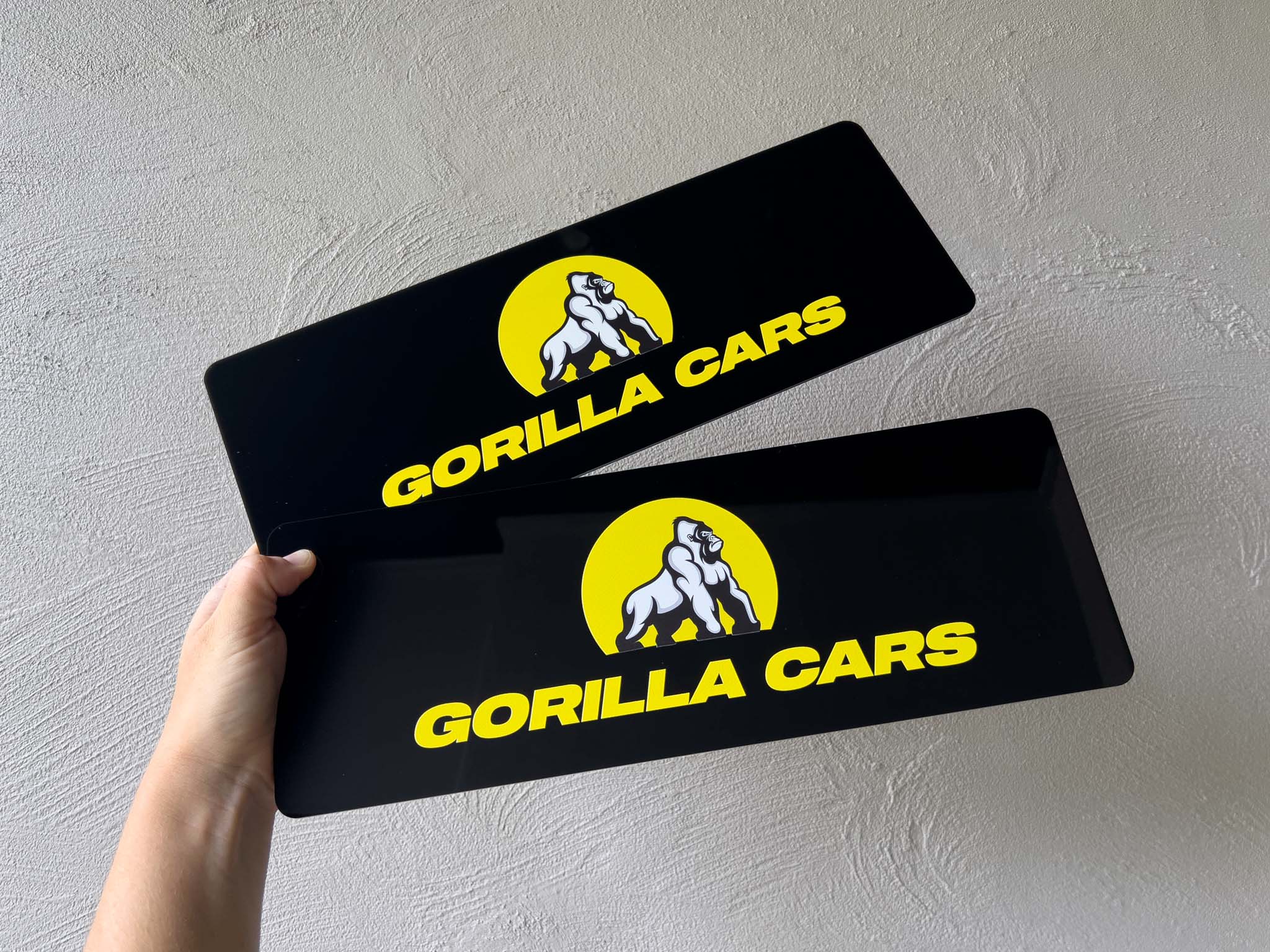 Two black gloss acrylic plates with logo 'Gorilla Cars' UV printed onto them.