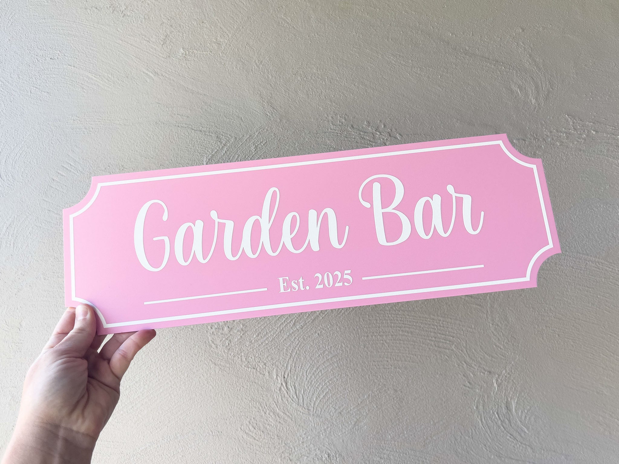 A classic style cursive script garden bar sign with inverted corner cut edges and Est. date.