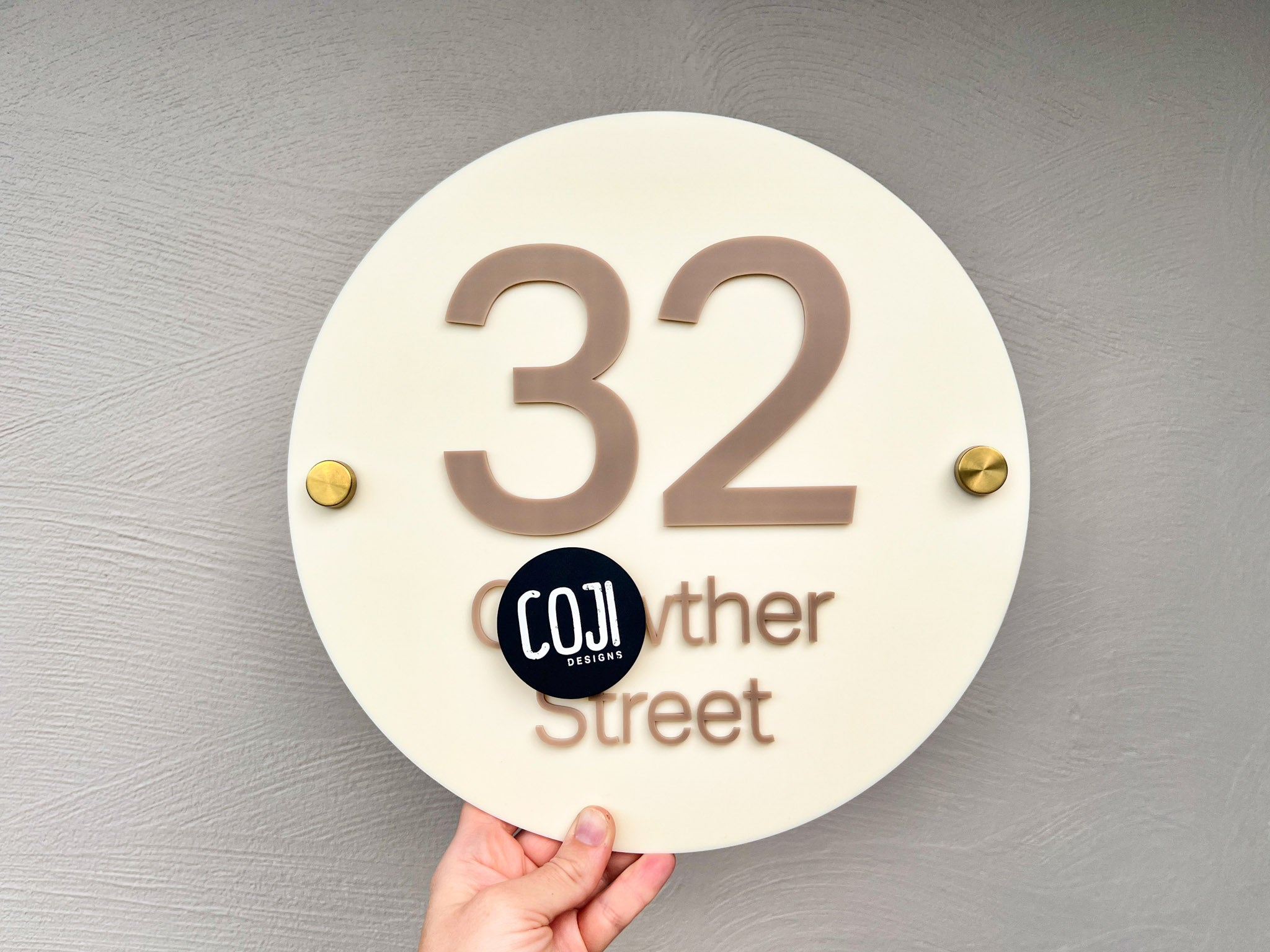 A simple classic street address sign in cream and taupe with number '32 Street' cut in 3D acrylic lettering.