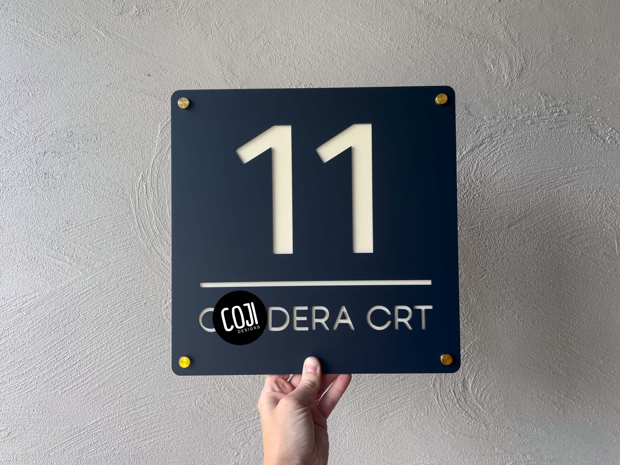 Classic Michigan address sign in a dark rustic blue and cream with gold mounts that reads '11 Crt'.