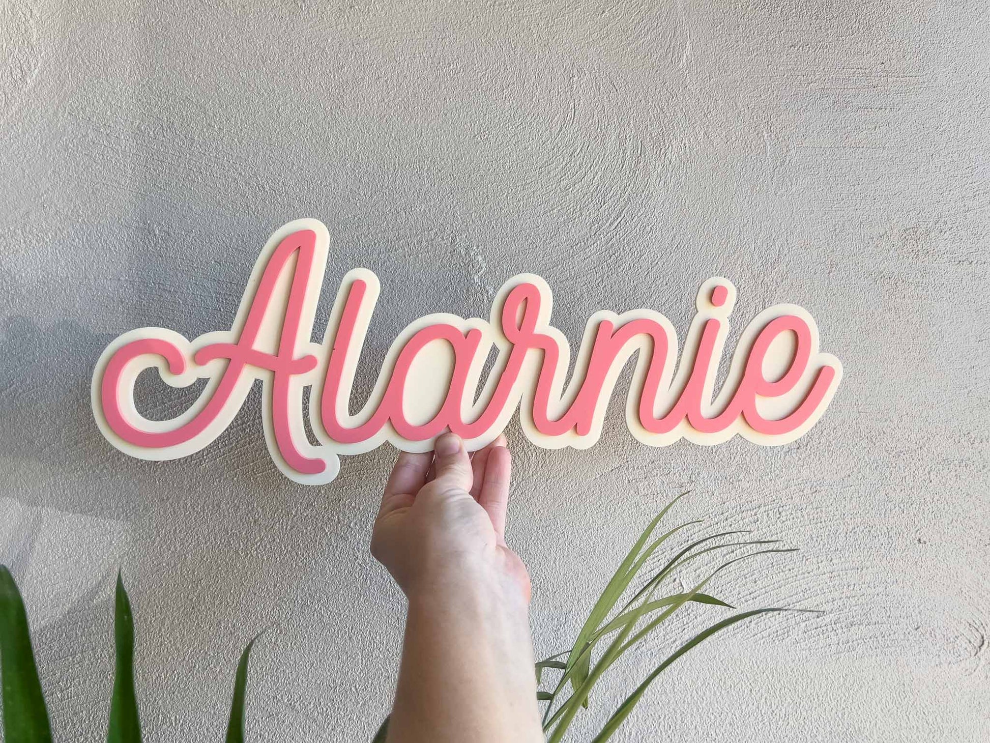 Cute beige and salmon pink colour 3D acrylic name plaque that says 'Alarnie'.