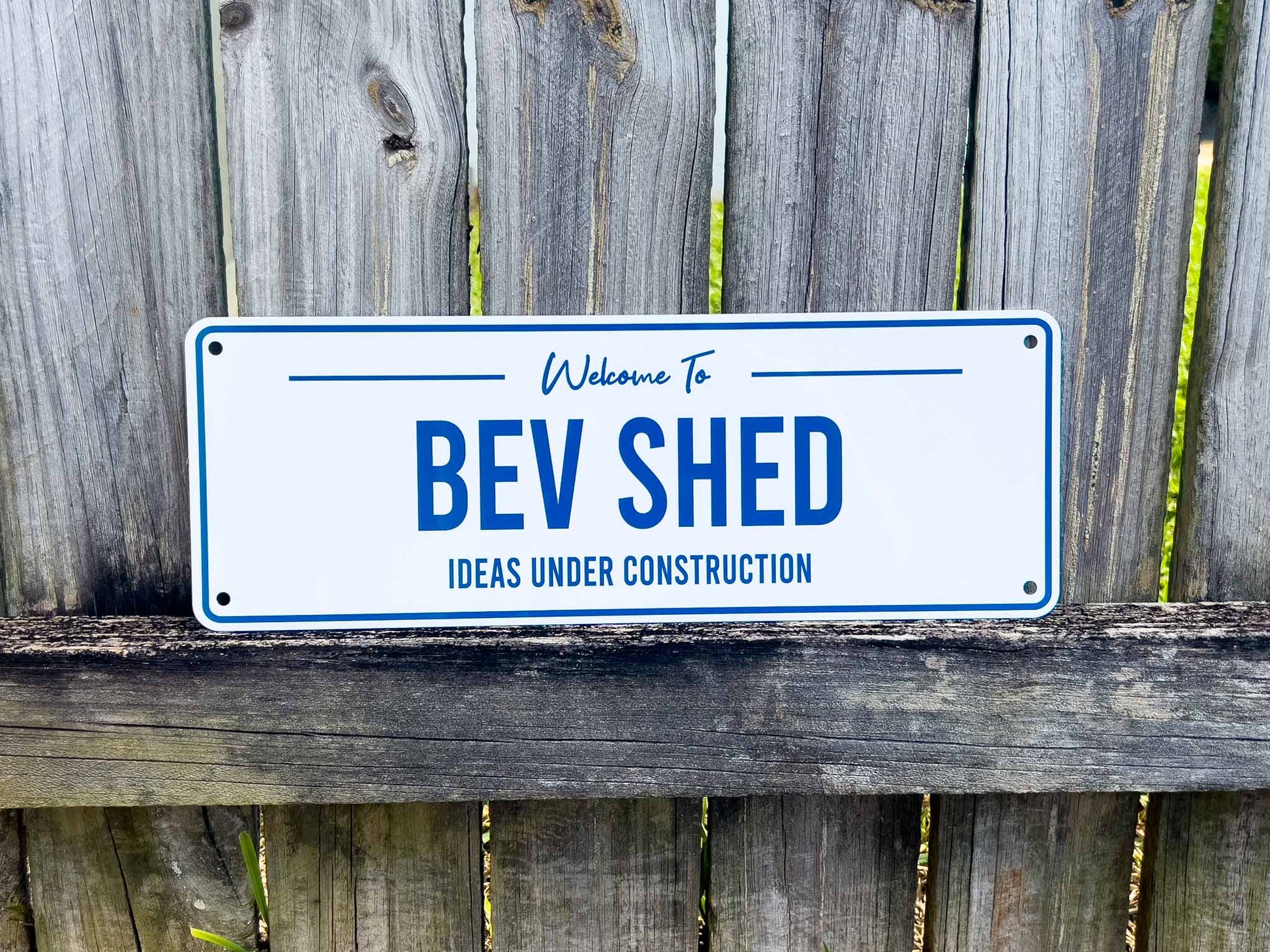 A white and blue sign that says 'Bev Shed Ideas Under Construction'.