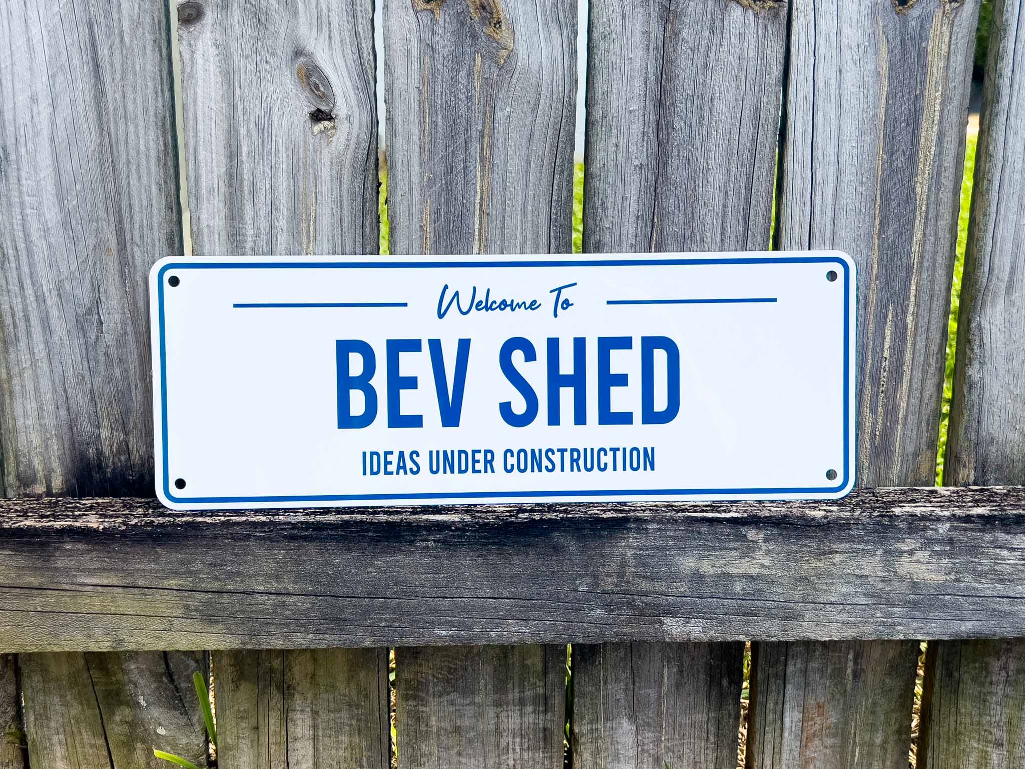 A white and blue sign that says 'Bev Shed Ideas Under Construction'.