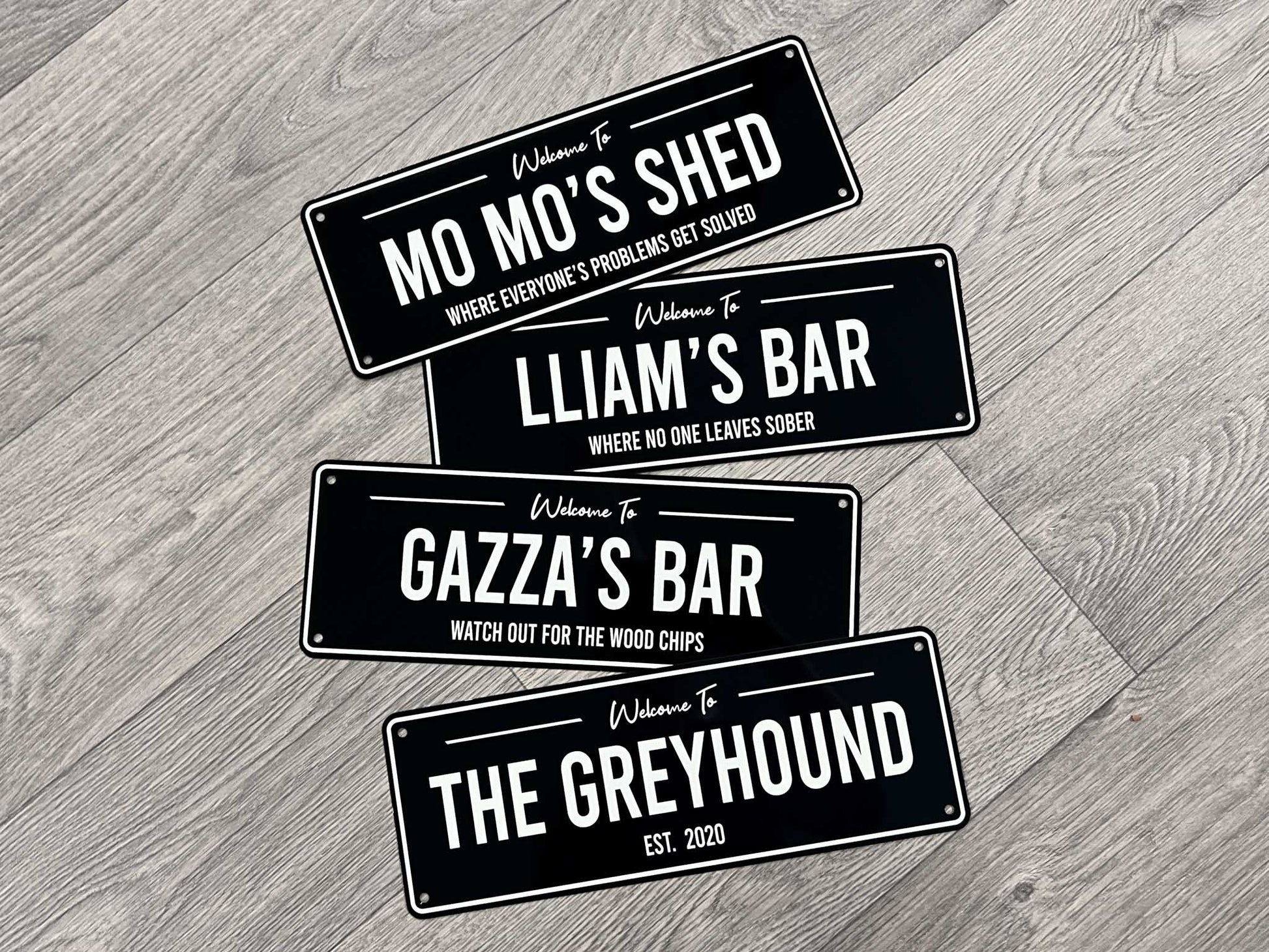A collection of personalised metal bar signs in black and white