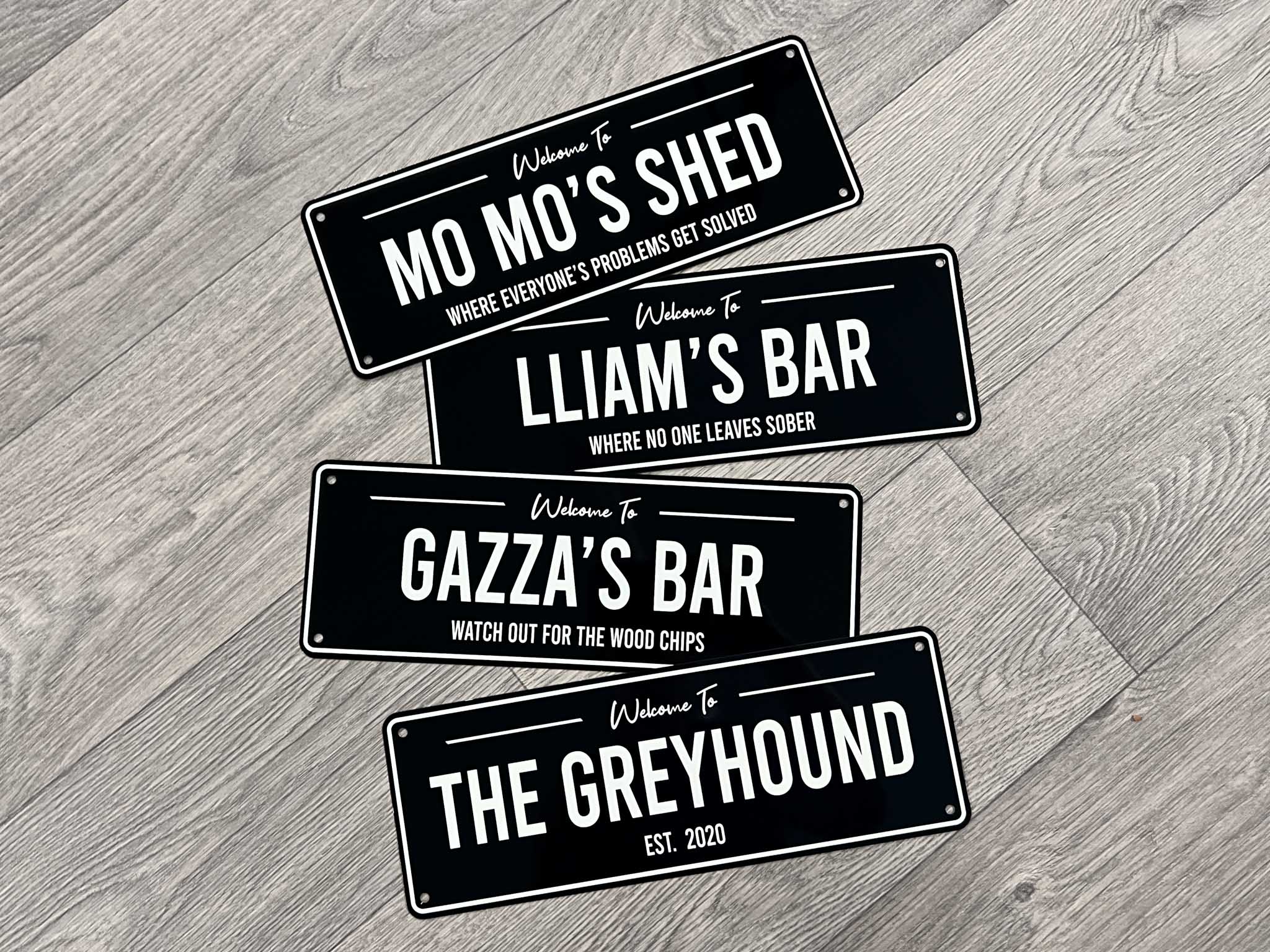A collection of personalised metal bar signs in black and white
