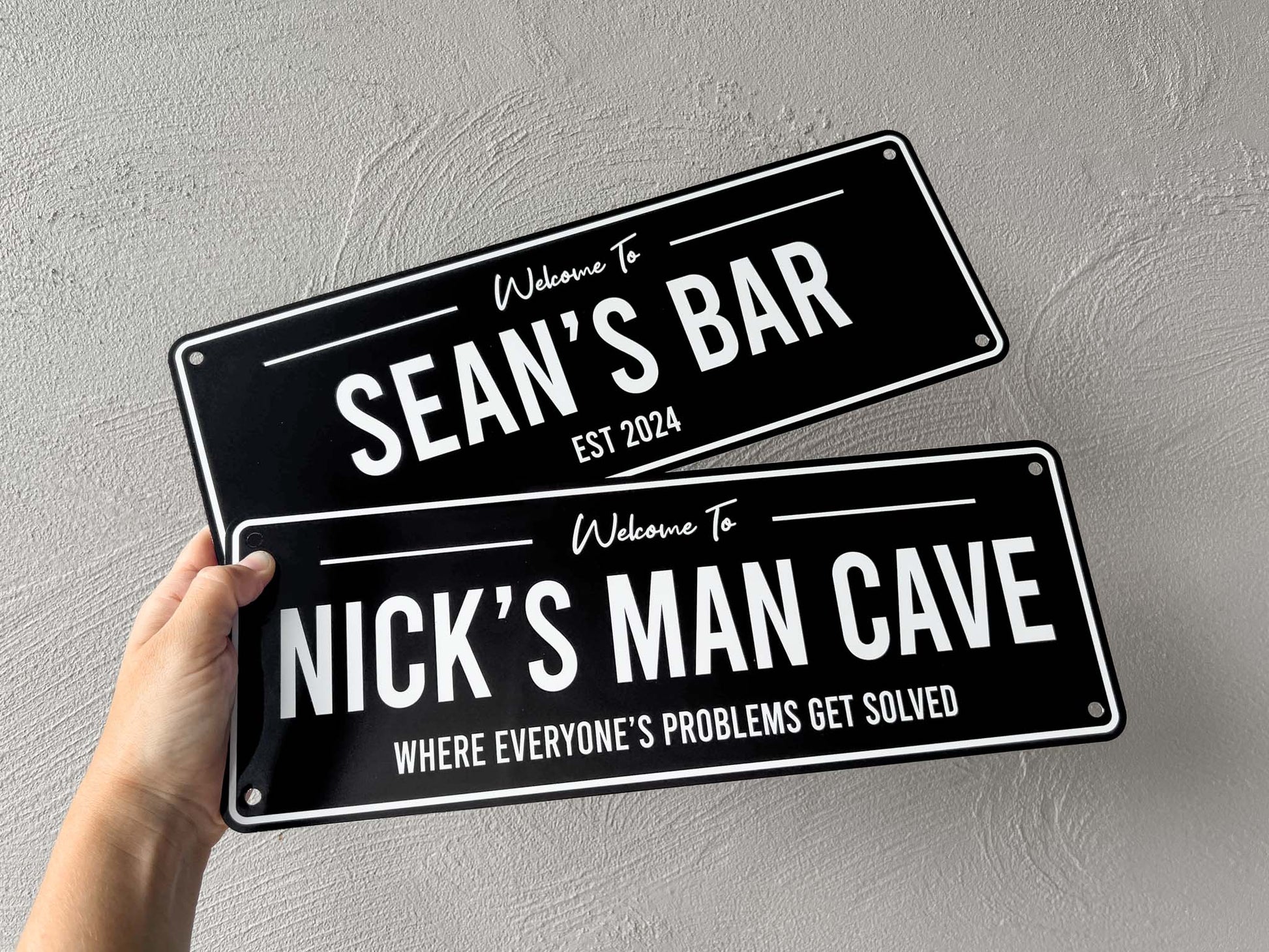 Two black and white bar signs that say 'Sean's Bar' & 'Nicks Man Cave'.