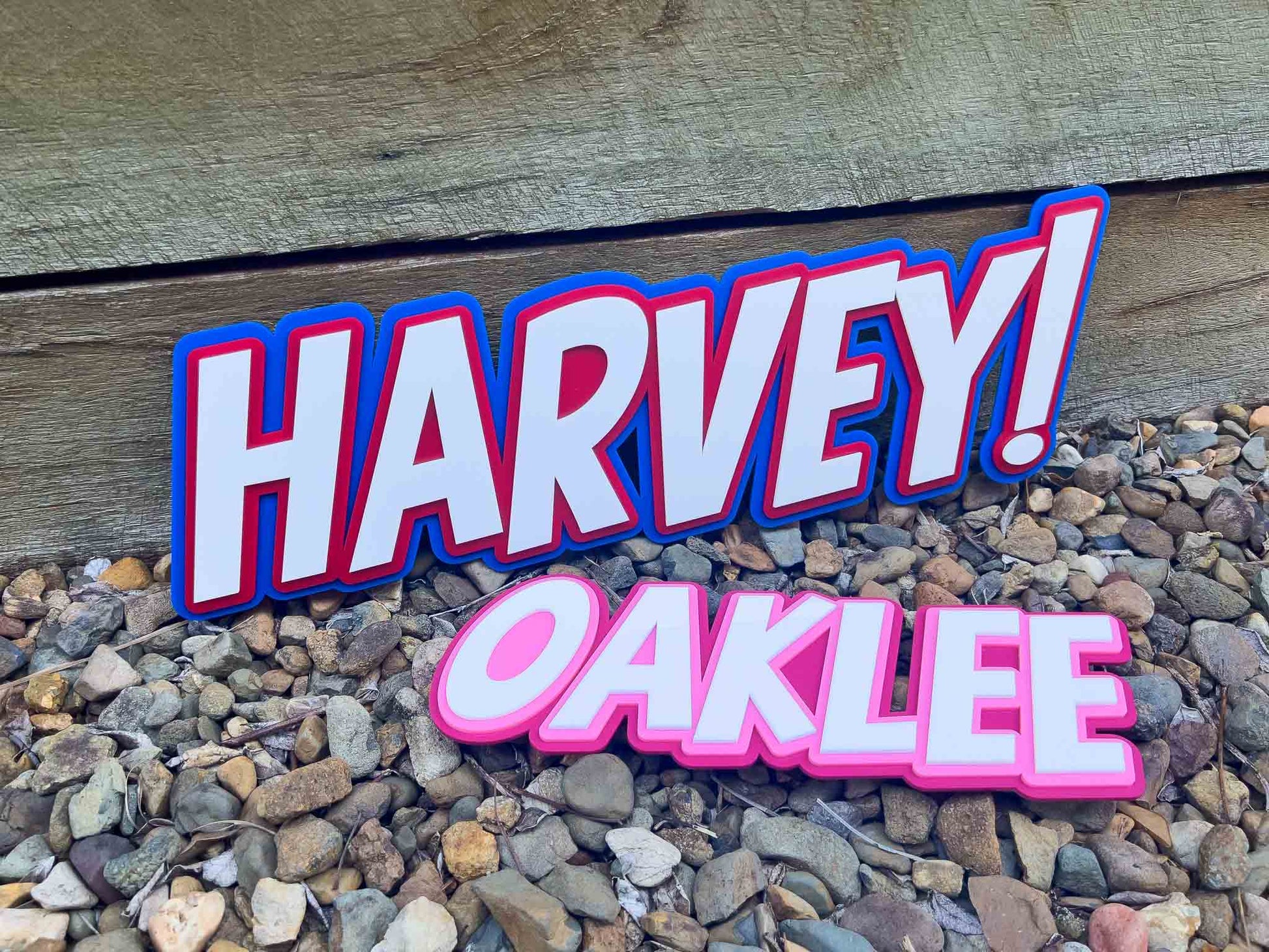 Triple layer 3D acrylic wall name plaque in blue and red for 'HARVEY!' and pink and white for 'OAKLEE'.