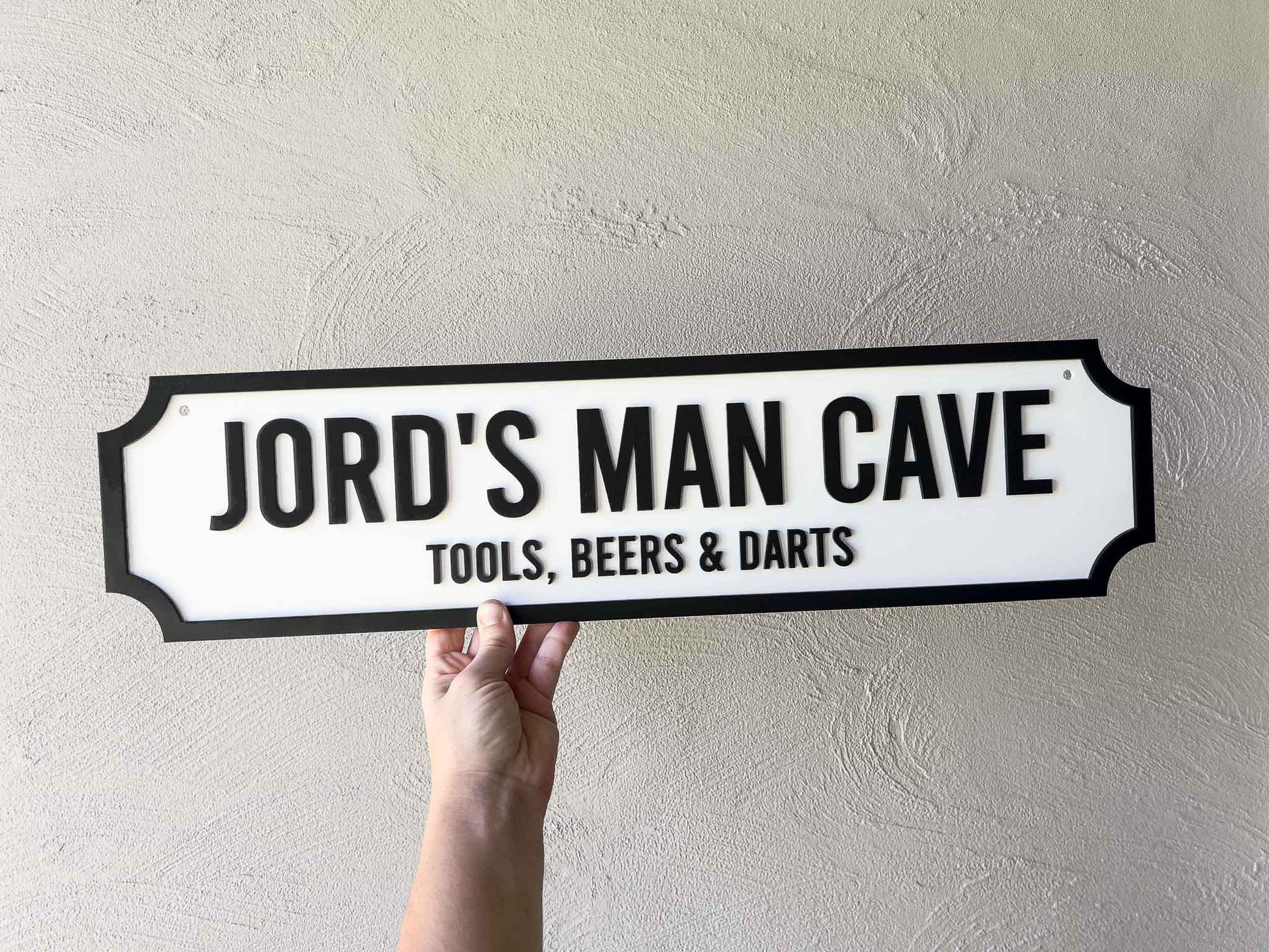 Custom made, classic 3D acrylic panel that reads 'JORD'S MAN CAVE' in white and black.