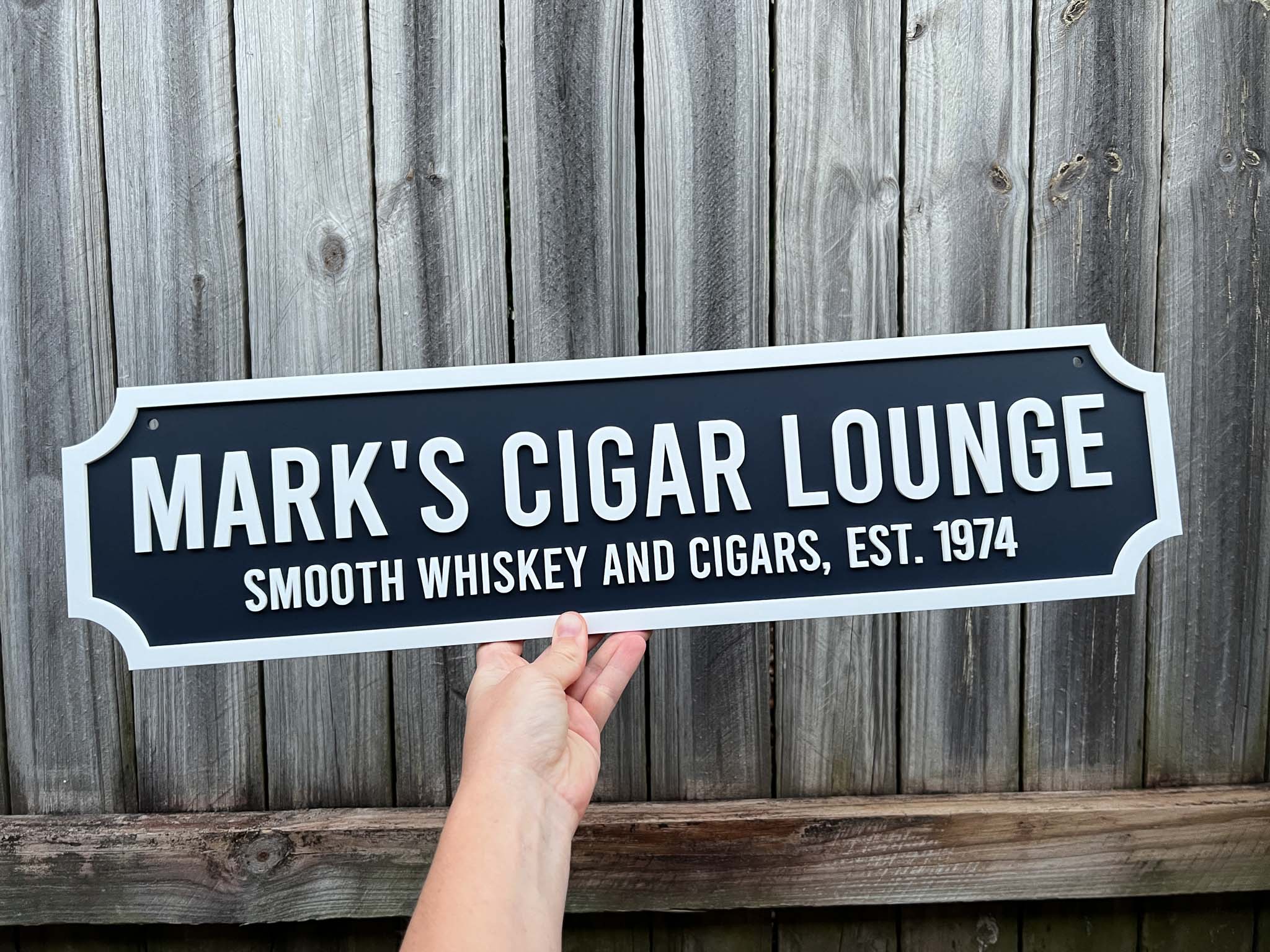 Traditional vintage 3D acrylic sign that reads 'Mark's Cigar Lounge' against a wooden background