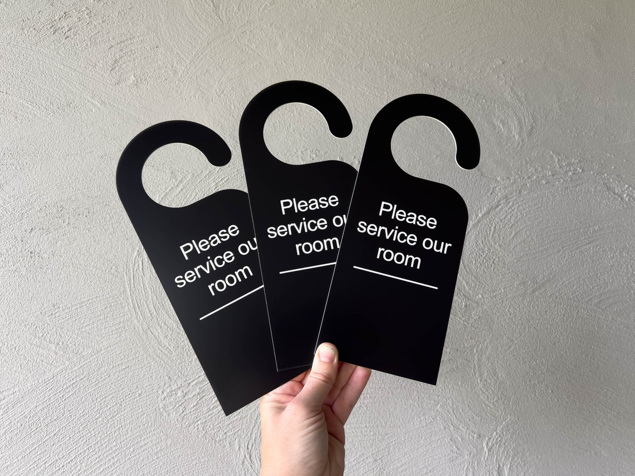 Custom engraved black and white door hanger that reads 'Please service our room' for a guest house | Coji Designs