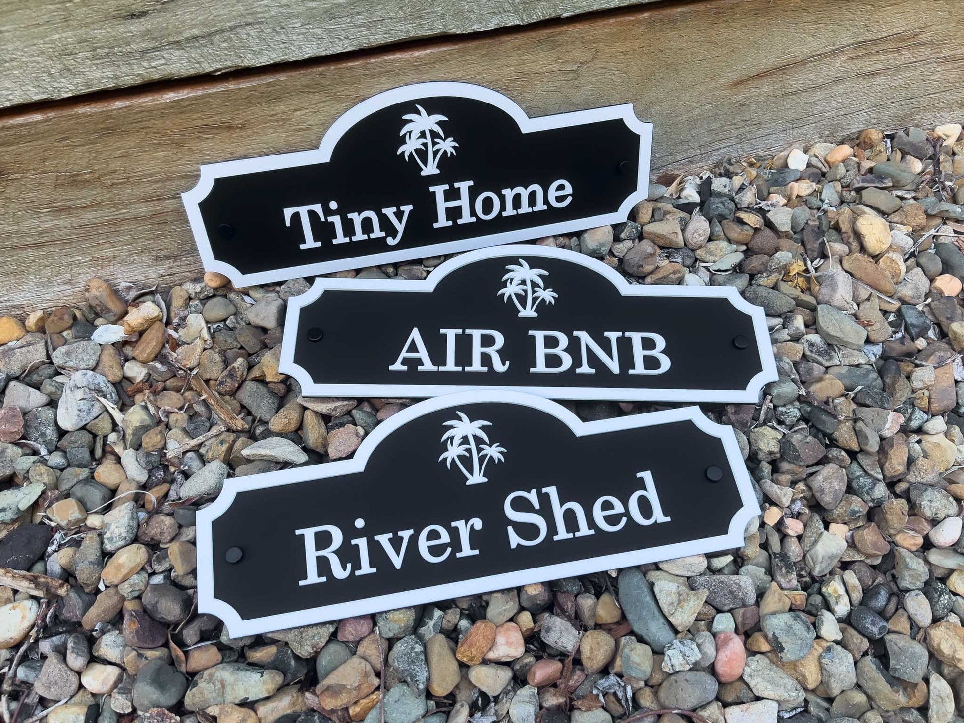 Custom made 3D laser cut acrylic signs with the words 'Tiny Home', 'AIR BNB' and 'River Shed' in black and white.