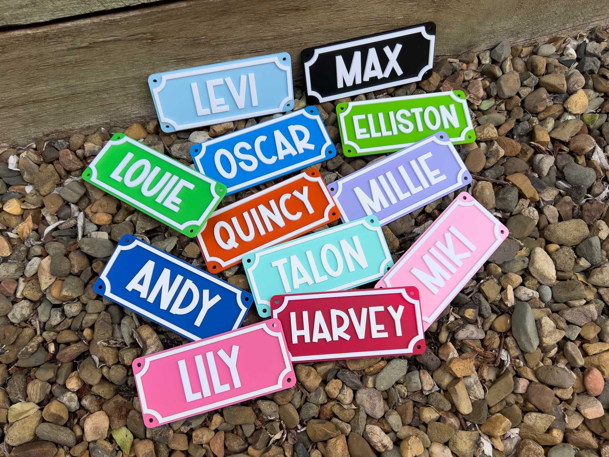 Colorful nameplates with various names on a pebble surface