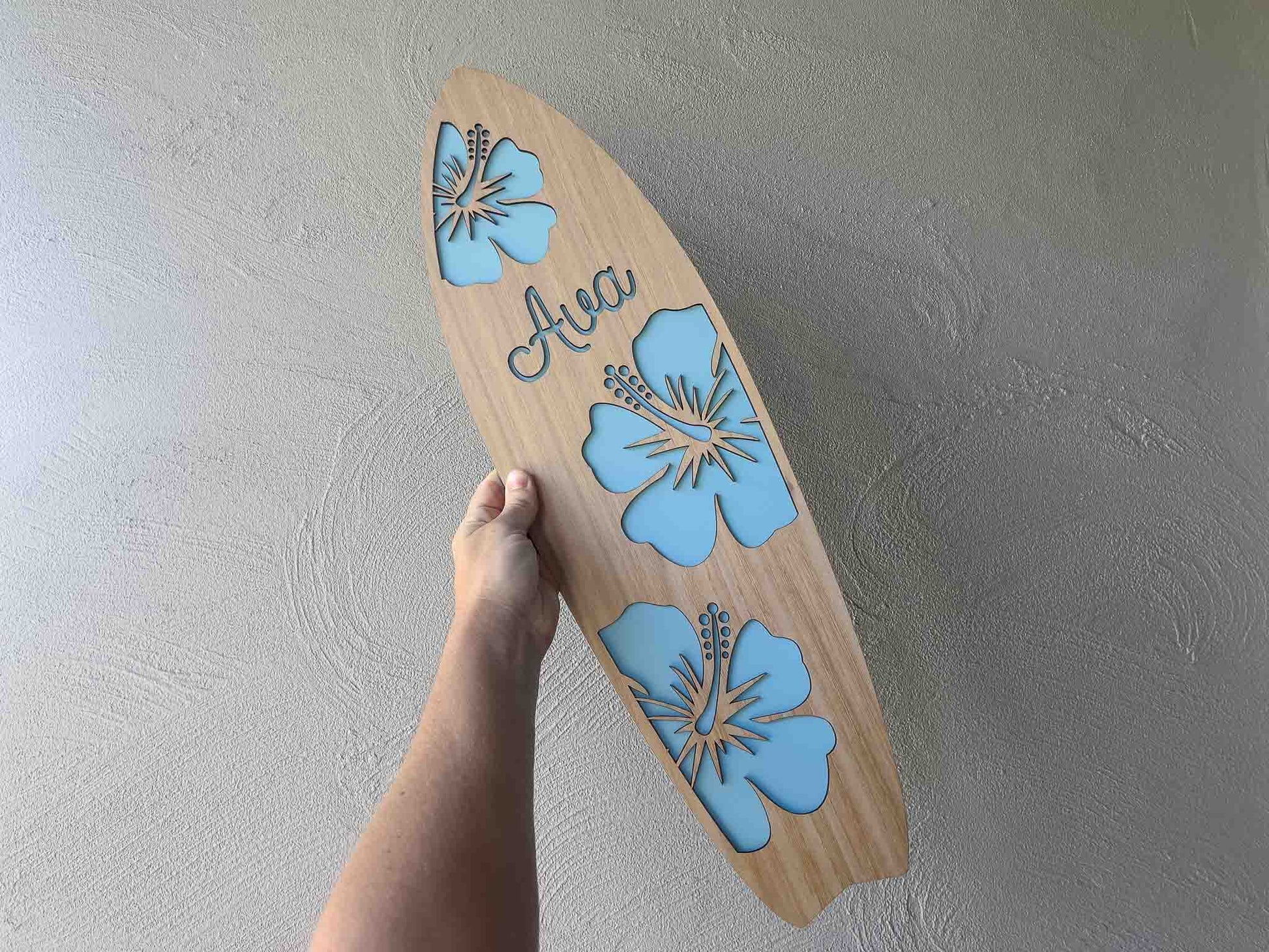 Beaufitul hibiscus flower timber surfboard sign with 'Ava' and a blue background.