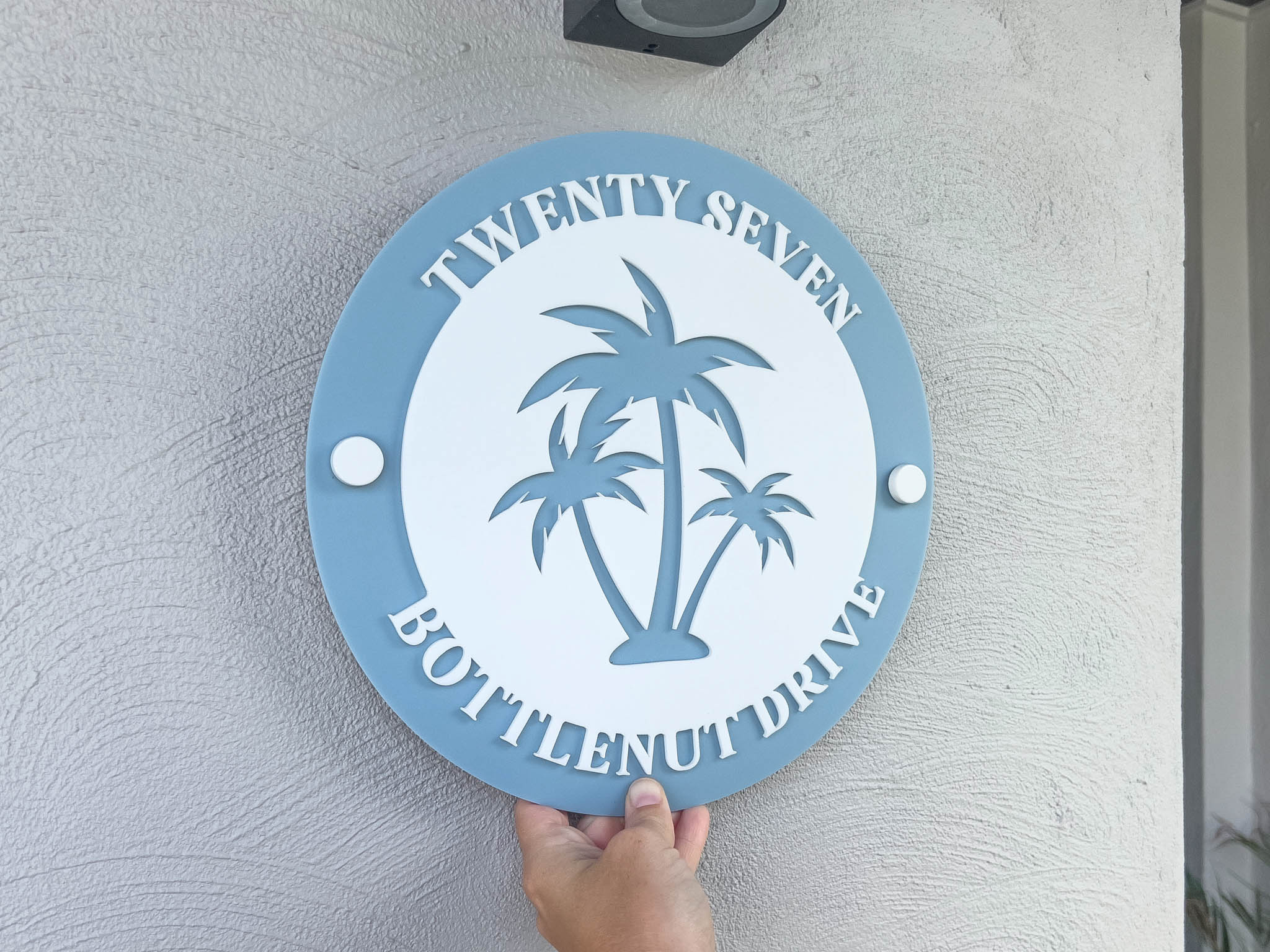 Circular laser cut 3D acrylic house sign custom made in a light coastal blue colour with white text.