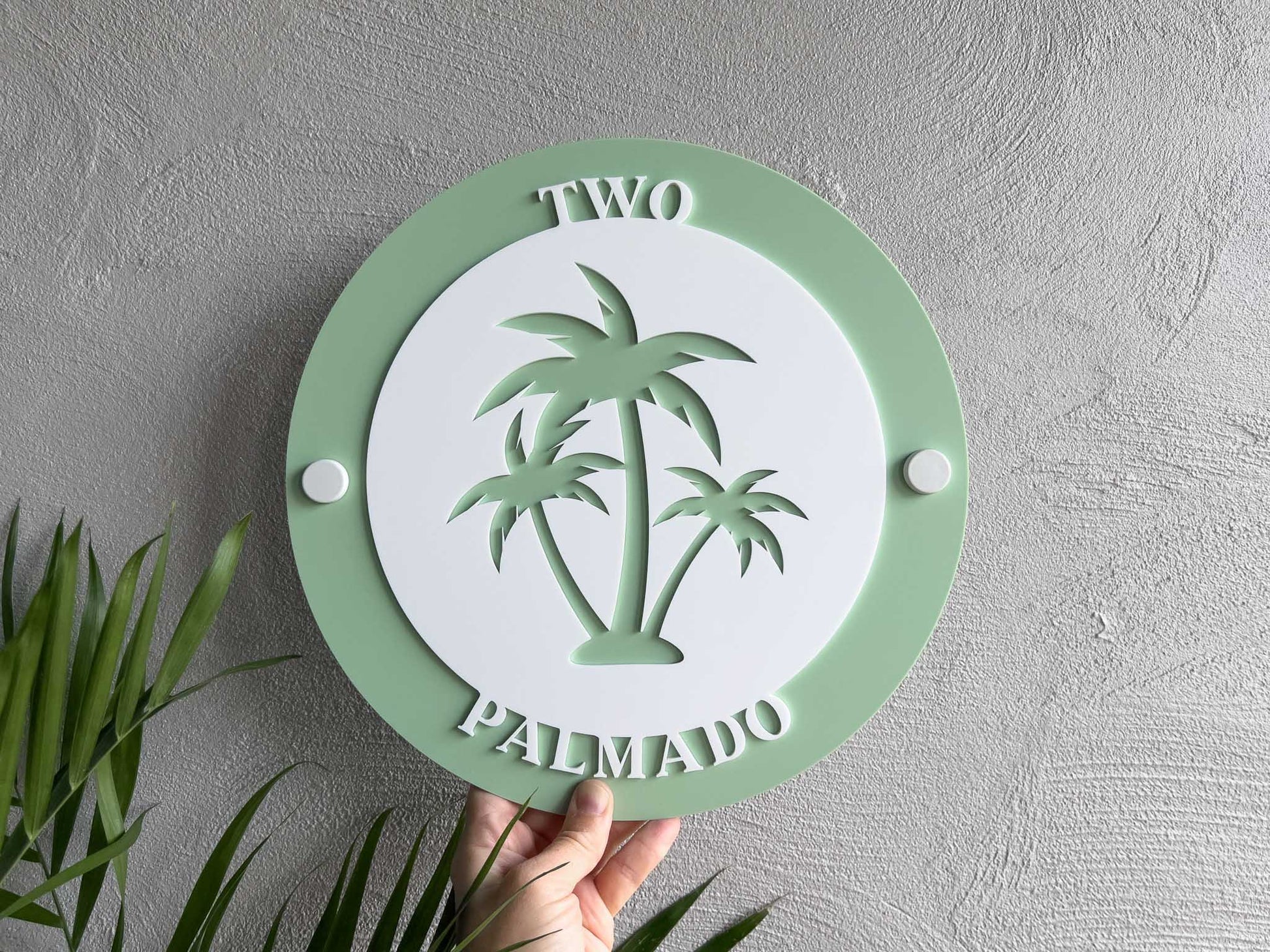 Sage green and white 3D acrylic layered adress sign with the number 'Two' mounted to a wall with white wall mounts.