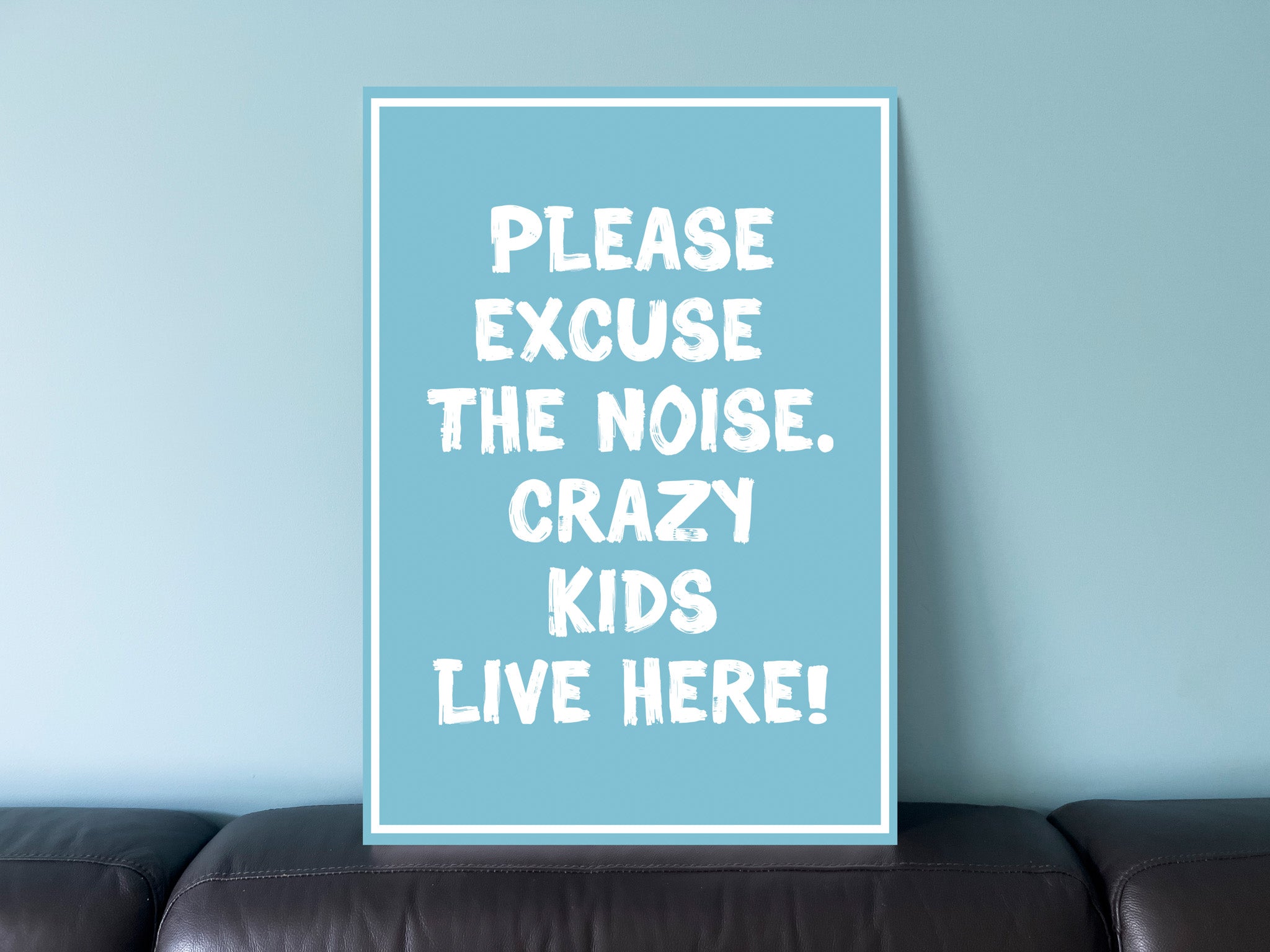 Seaside coastal blue sign that says 'Please excuse the noise, crazy kids live here!'