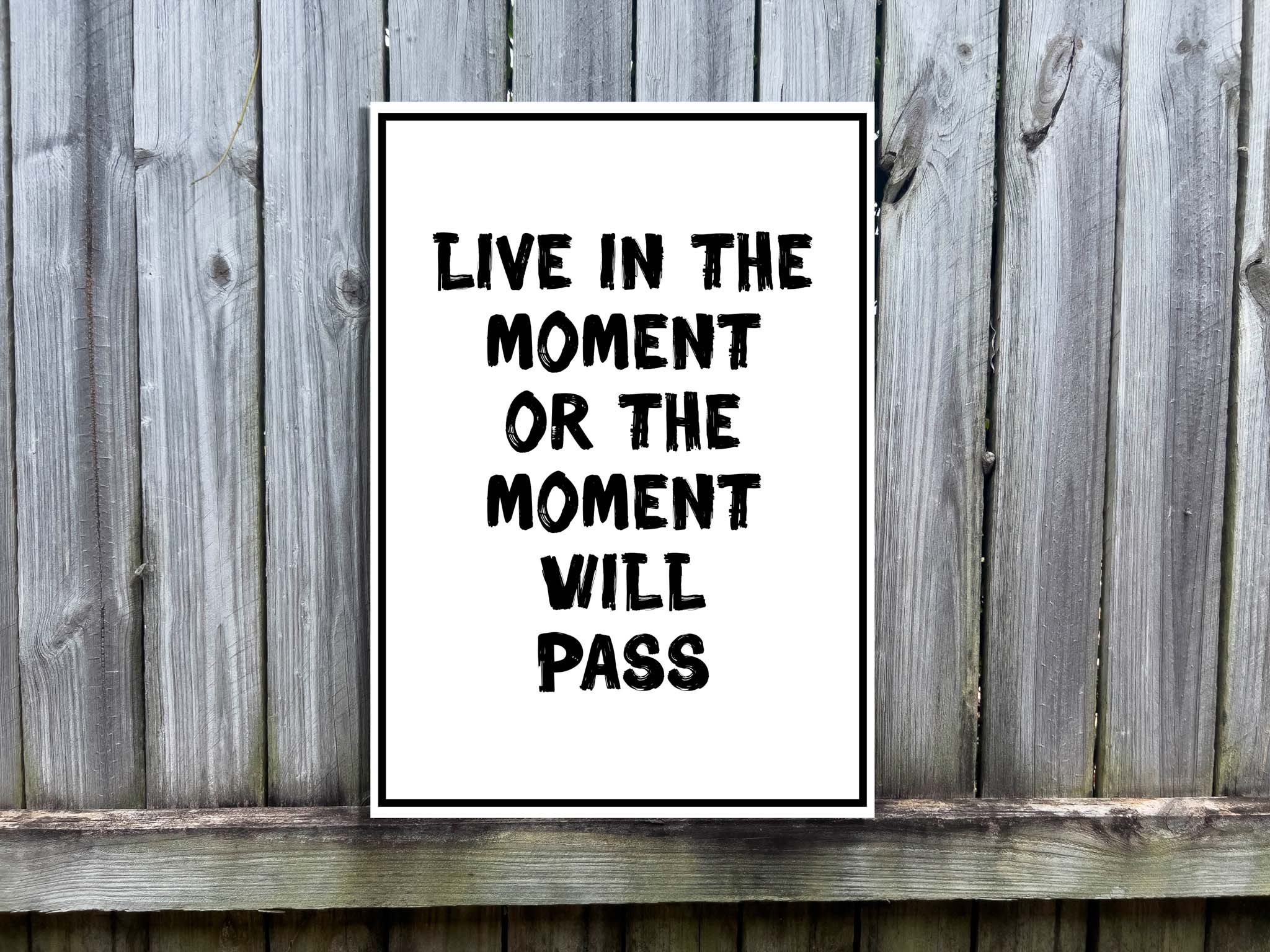 Custom UV printed acrylic text sign that says 'Live in the moment or the moment will pass' in white and black.
