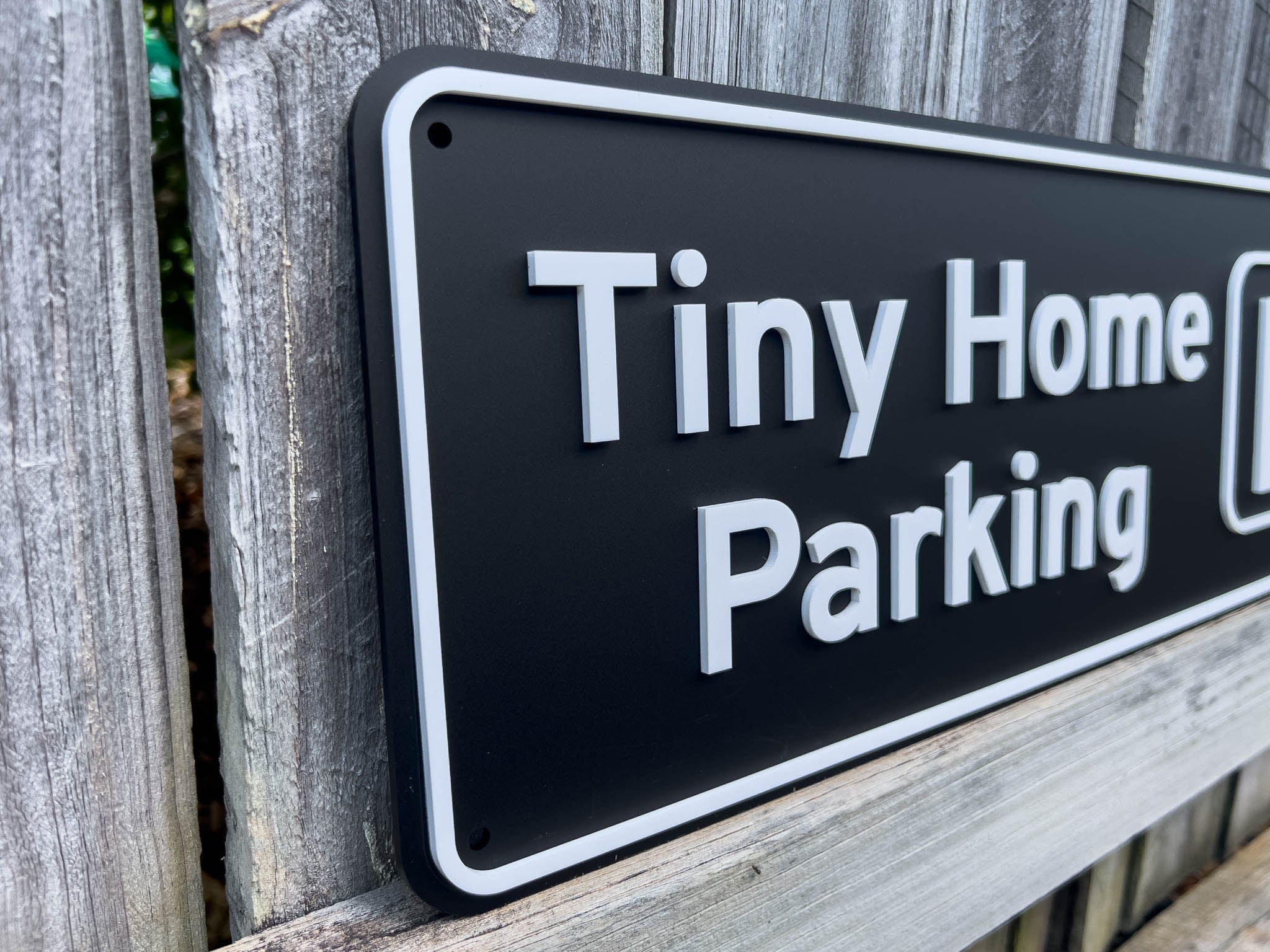 Black sign with 'Tiny Home Parking' text on a wooden background | Coji Designs