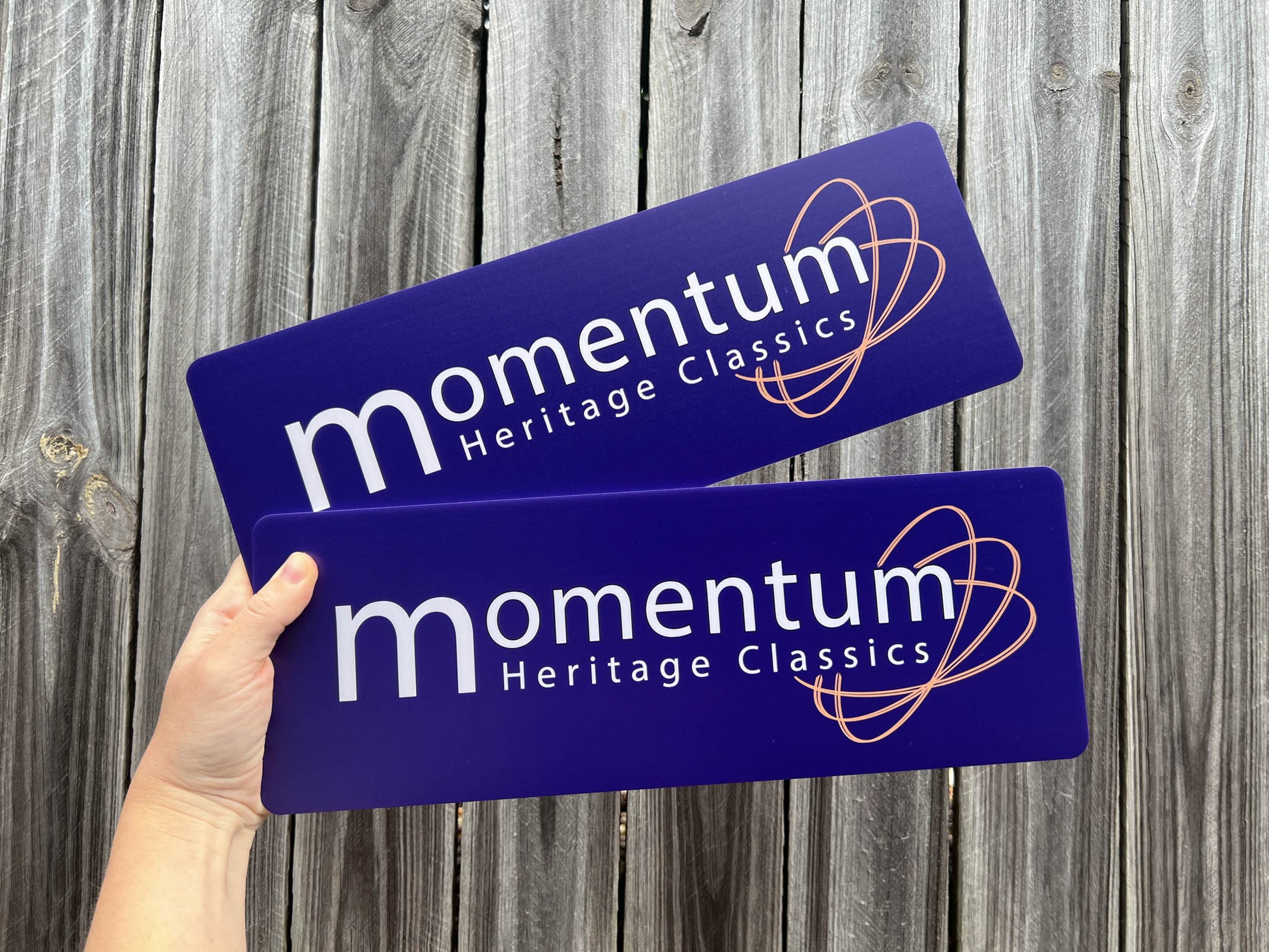 Two 'momentum Heritage Classics' signs held against a wooden background