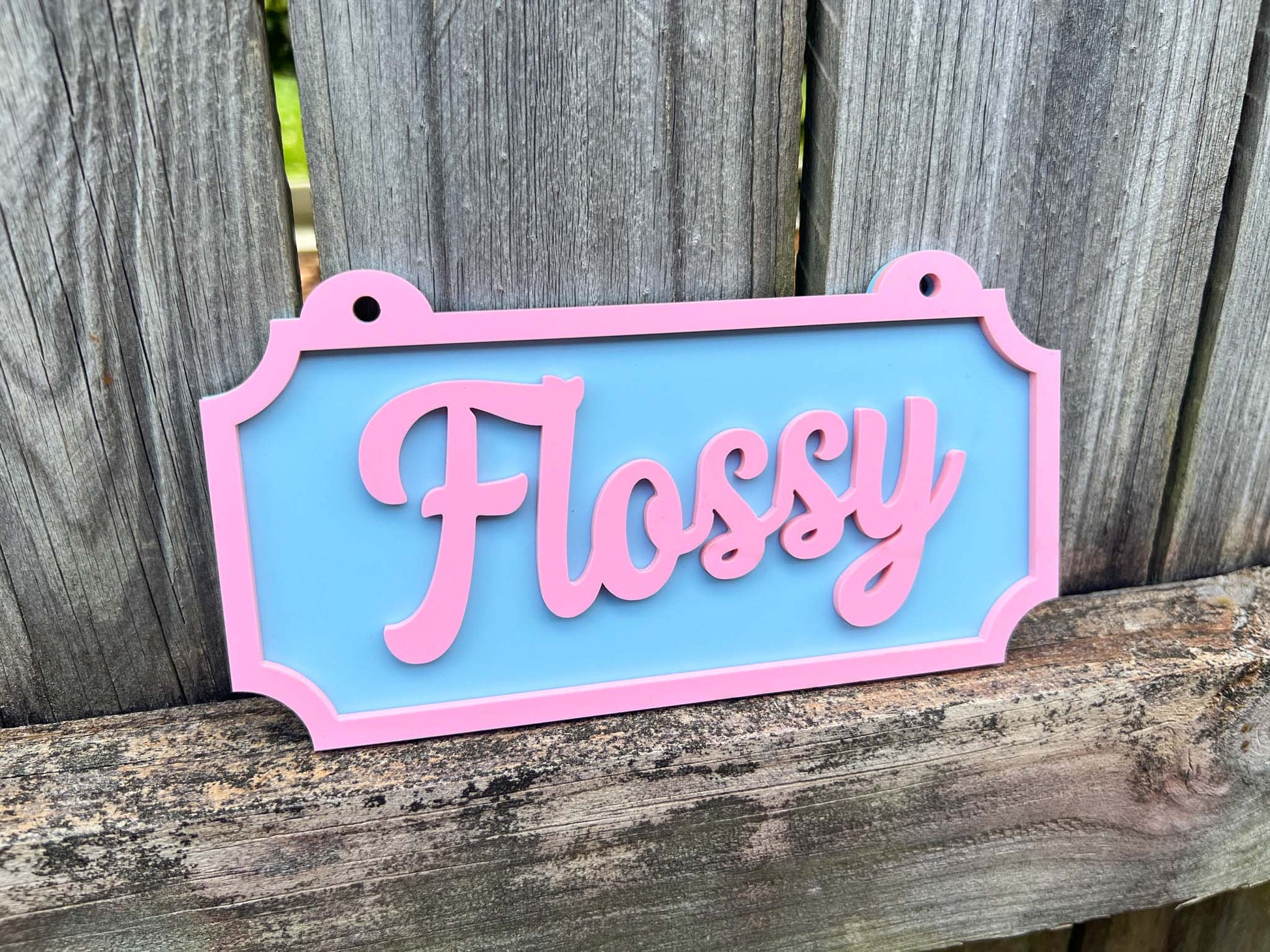 Decorative sign with 'Flossy' on a wooden background | Coji Designs