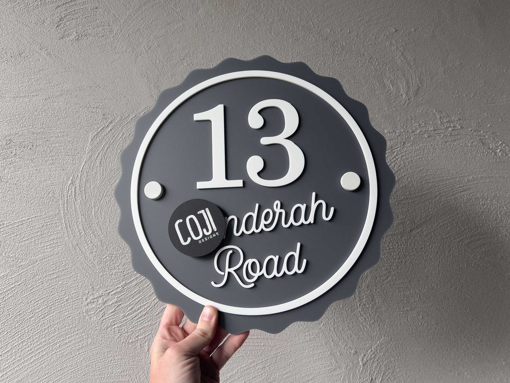 A contemporary style 3d acrylic address sign with the number '13' in a smoke grey and white colour.