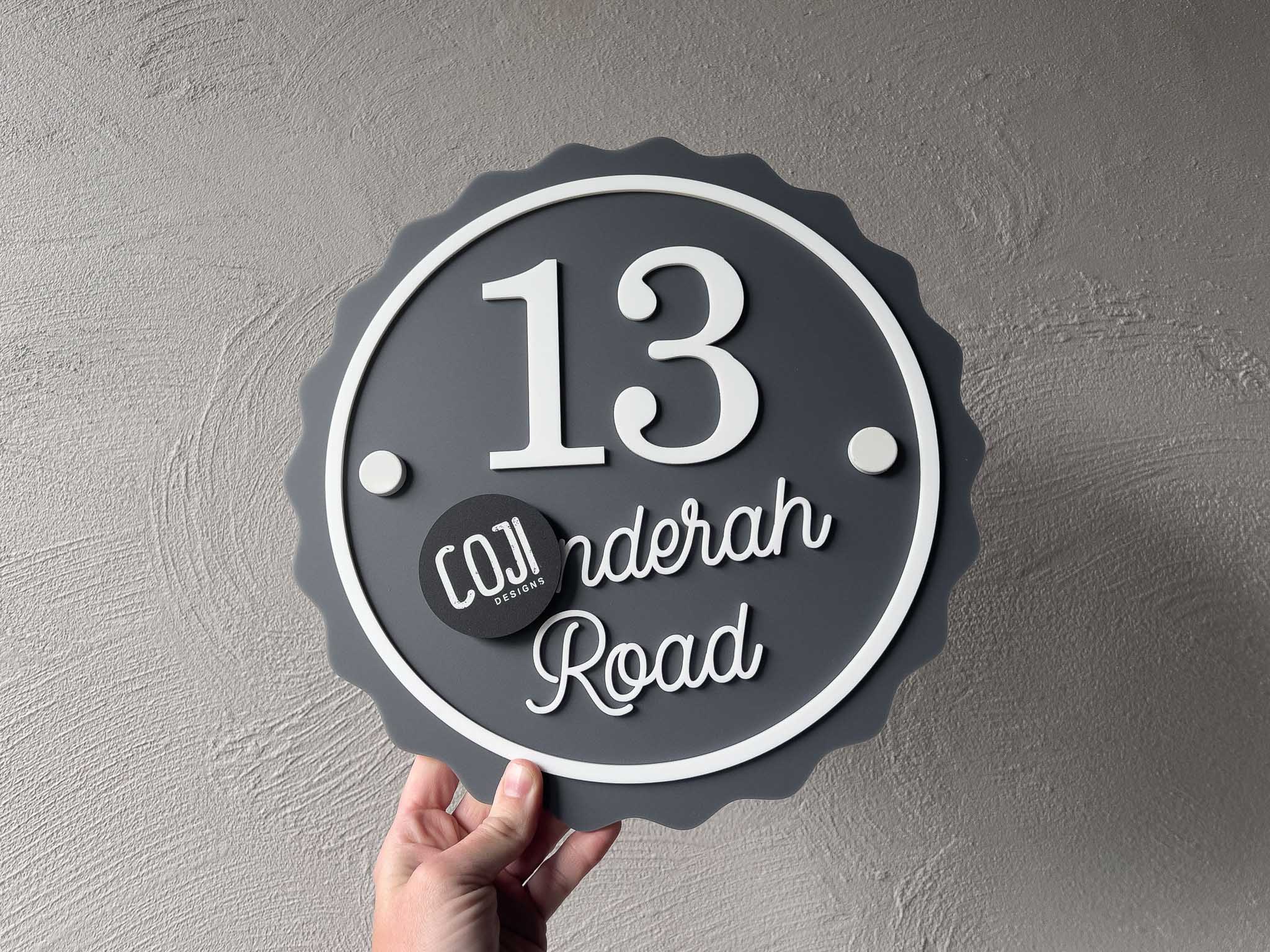 A contemporary style 3d acrylic address sign with the number '13' in a smoke grey and white colour.