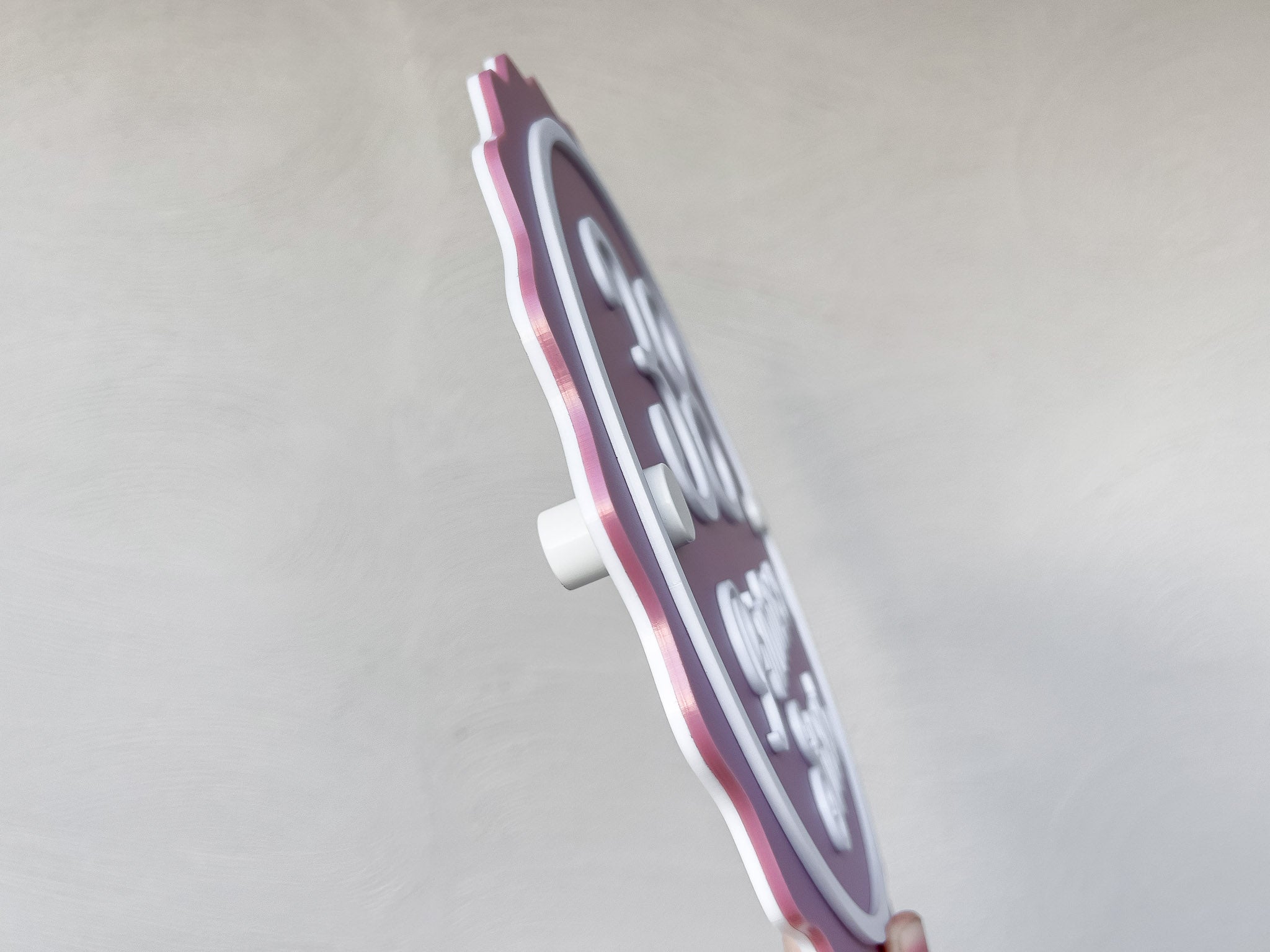A side view of a custom made 3D acrylic address sign in dusty pink and white.