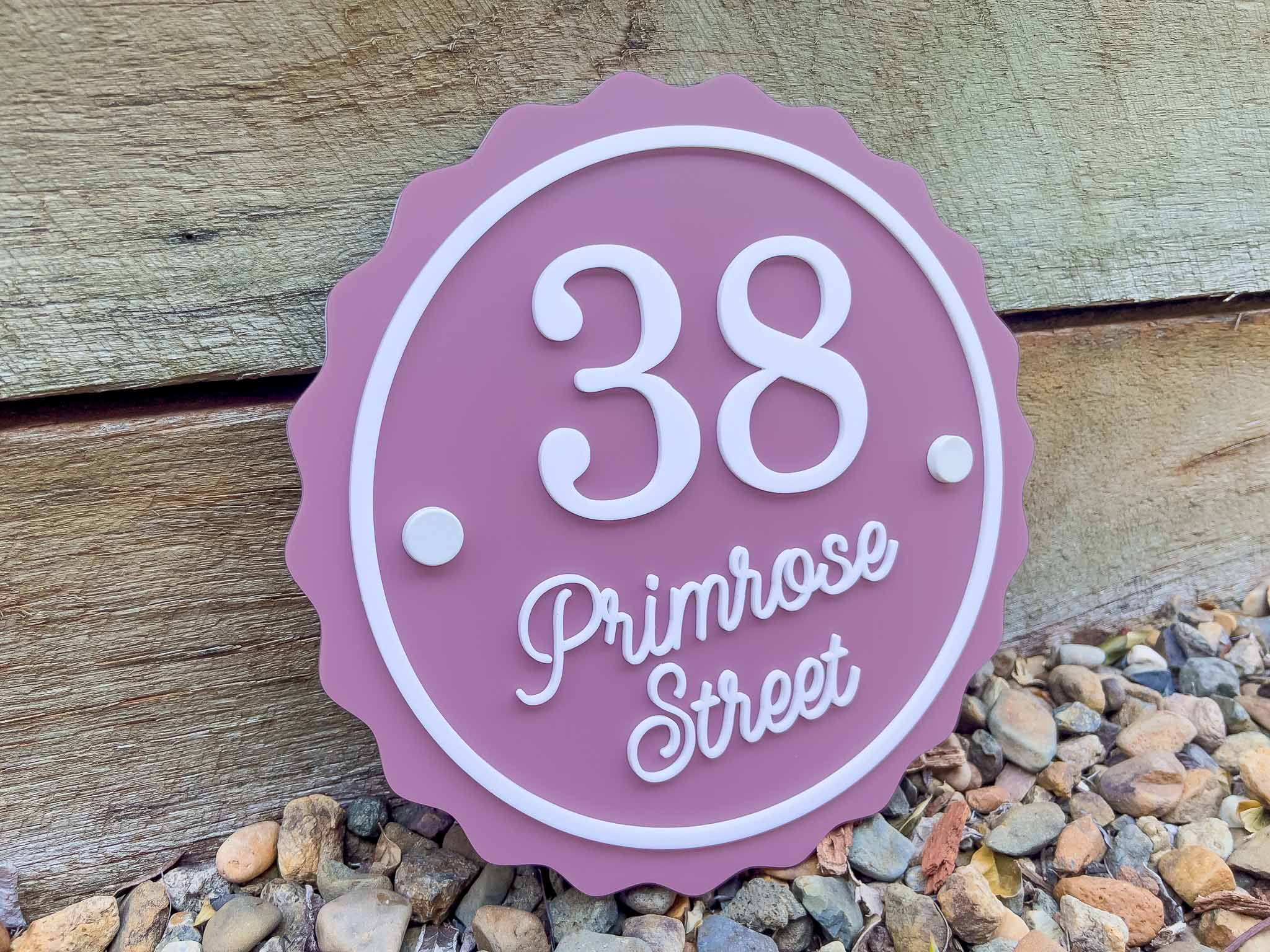Custom made pink house number sign with '38 Primrose Street' on a wooden background