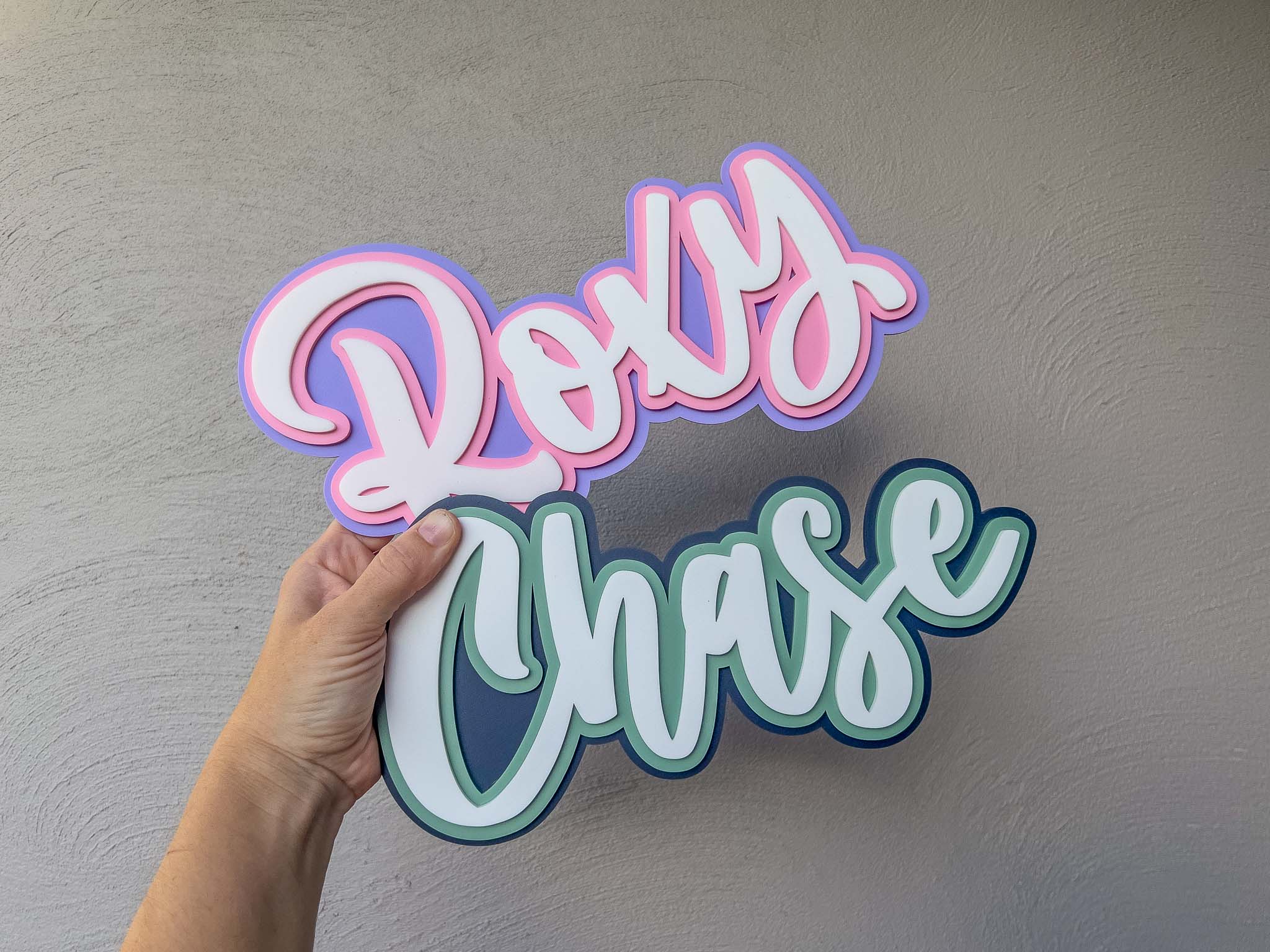 Iconic skate-style custom acrylic name plaques that read 'Roxy' & 'Chase' in pink, purple and blue and green.