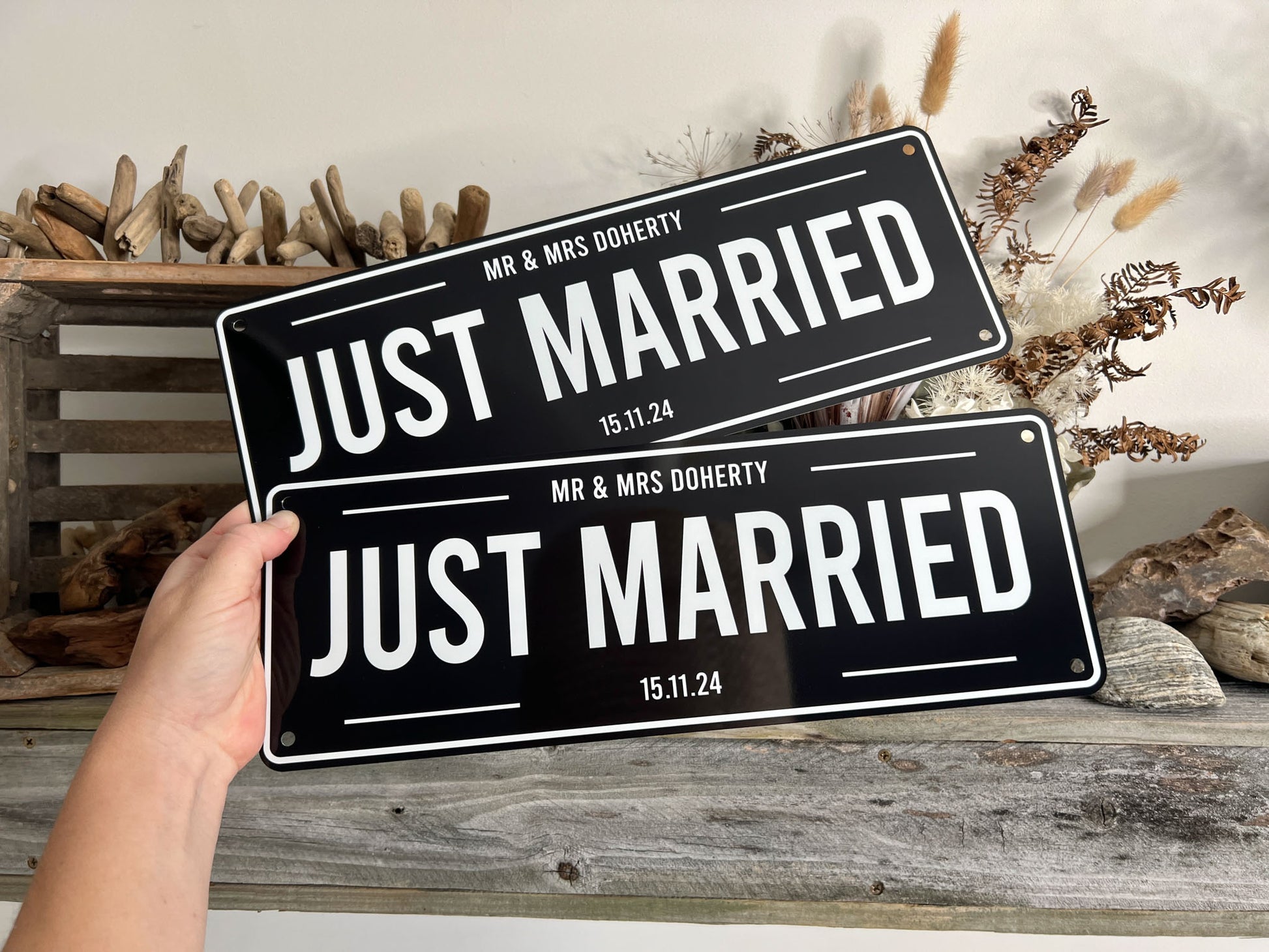 Two 'Just Married' signs held by a hand with decorative background | Coji Designs