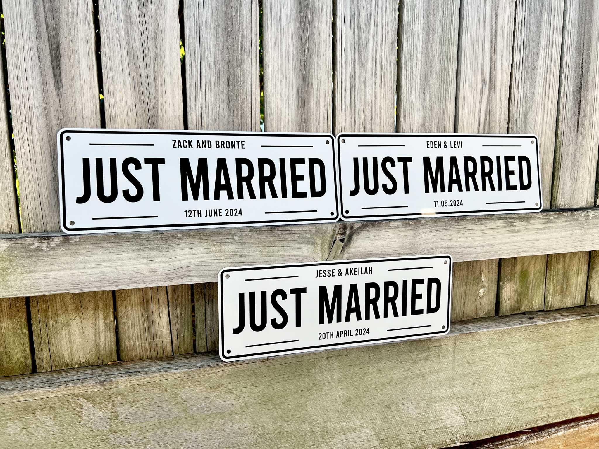 Three 'Just Married' Wedding signs with personalized dates on a wooden background | Coji Designs