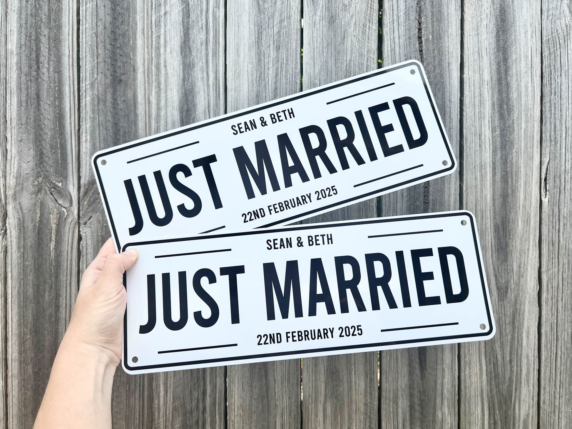 Two 'Just Married' signs held against a wooden background | Coji Designs