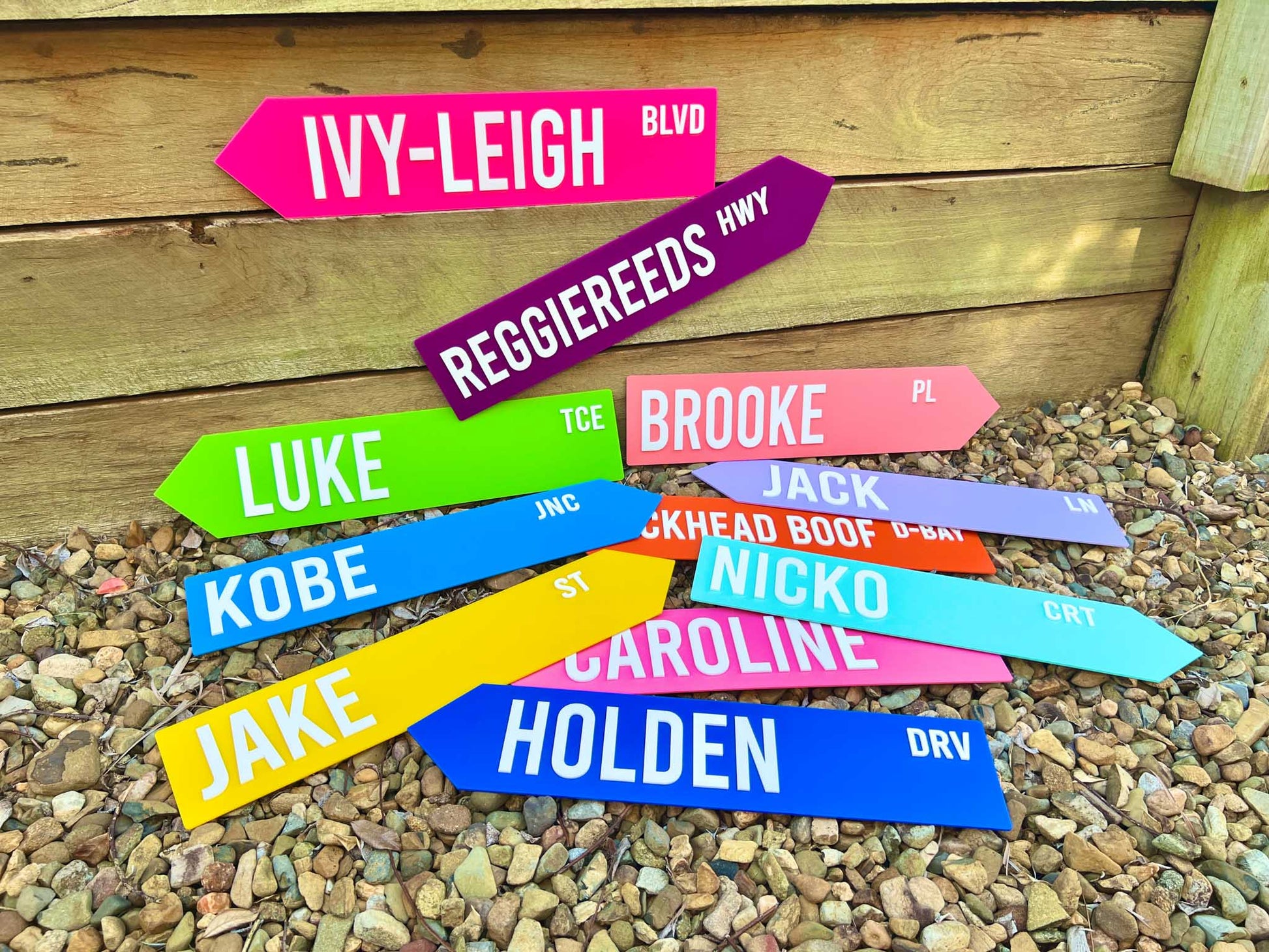 Colorful street name signs on a wooden background | Coji Designs