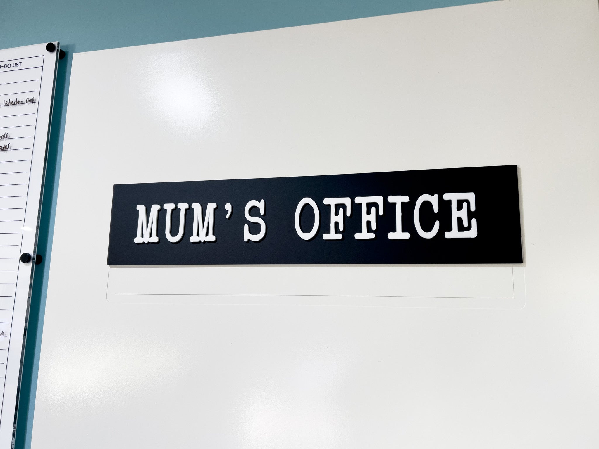 Personalised black and white 'MUM'S OFFICE' door plaque in a classic typewritter font.