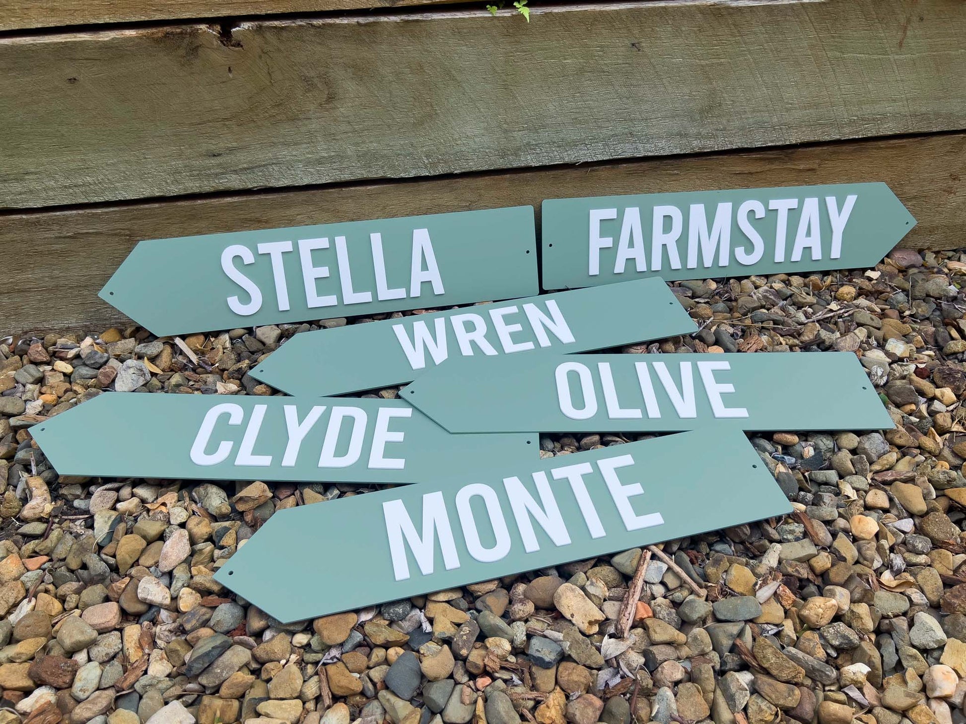 Set of green wooden signs with names on a gravel surface | Coji Designs
