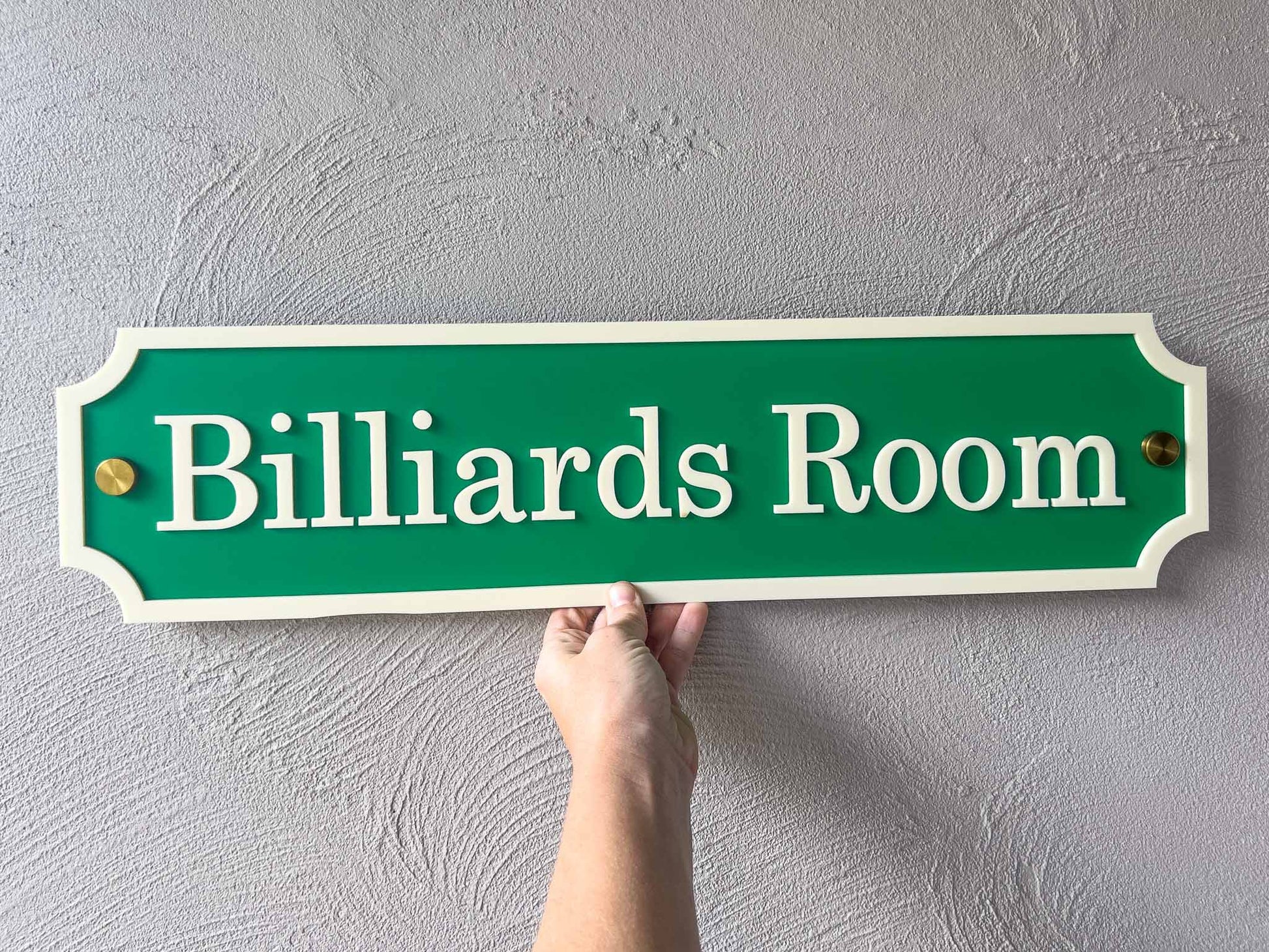 A classic billiards green and cream sign with gold mounts that says 'Billiards Room'.
