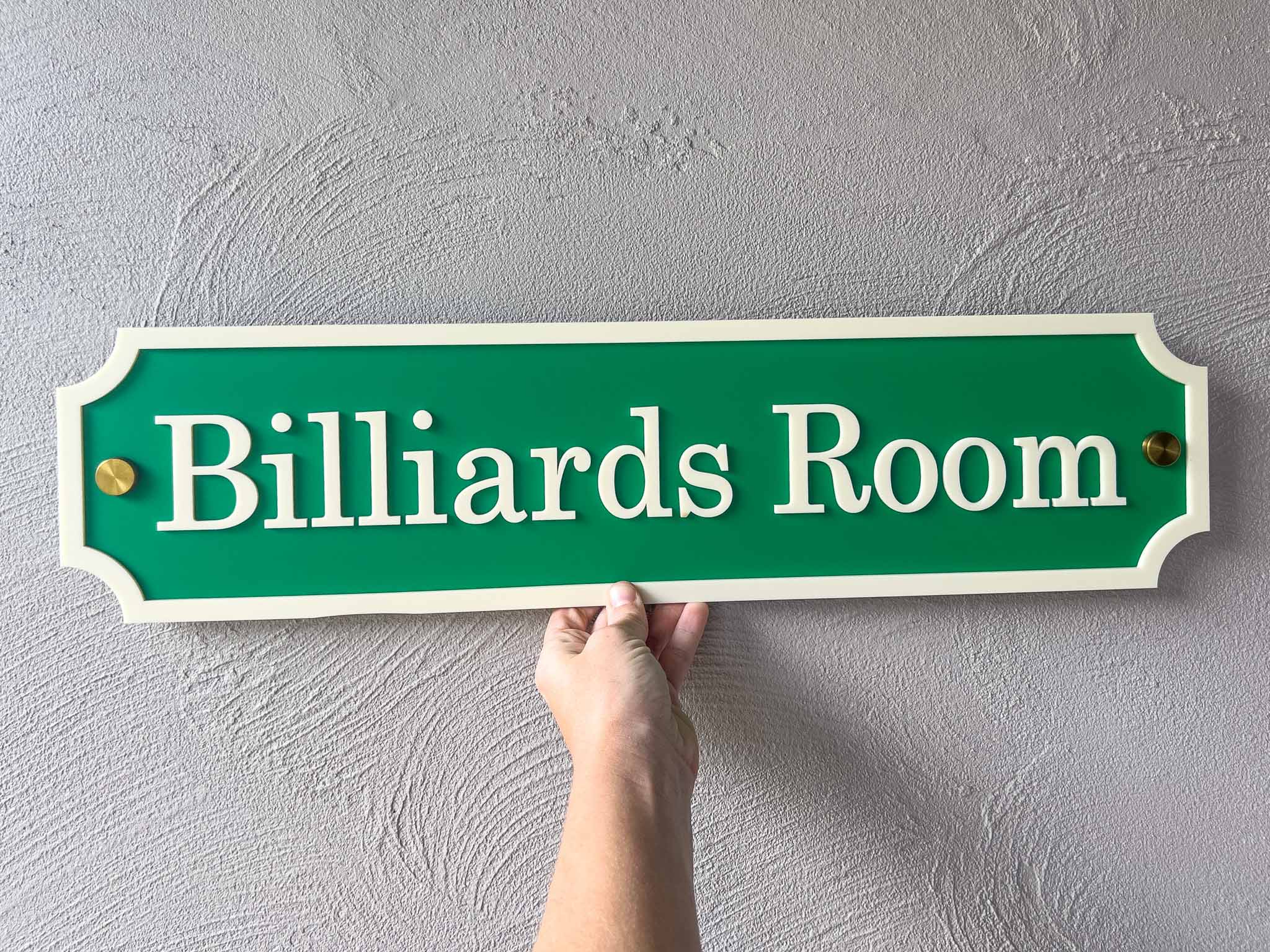 A classic billiards green and cream sign with gold mounts that says 'Billiards Room'.