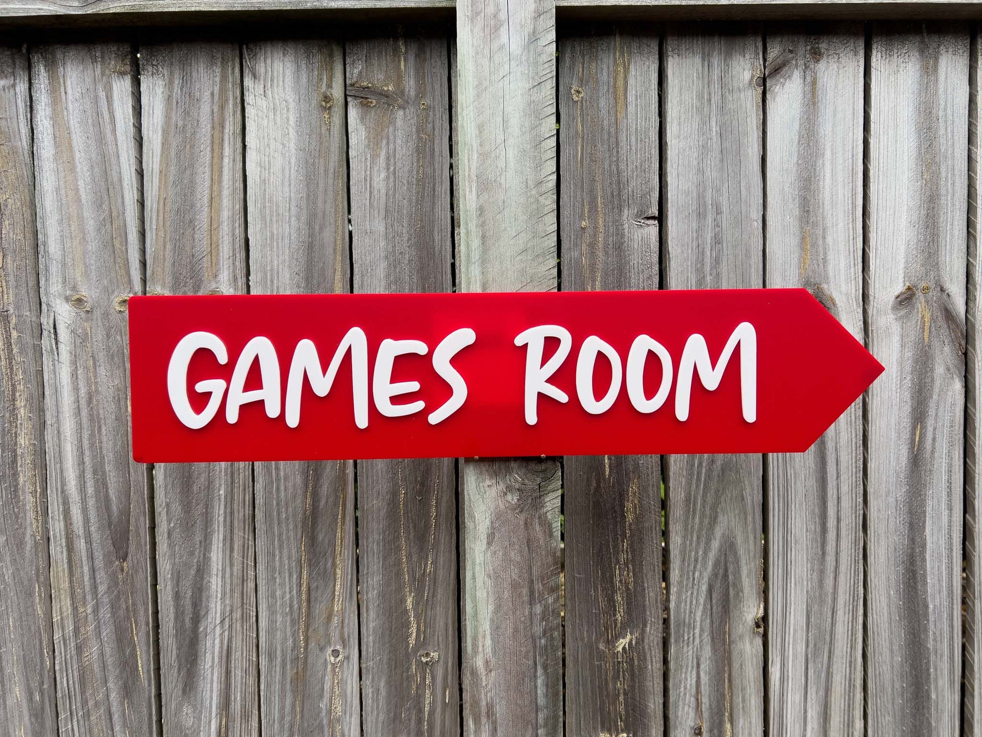 Red sign with 'GAMES ROOM' text on a wooden background | Coji Designs