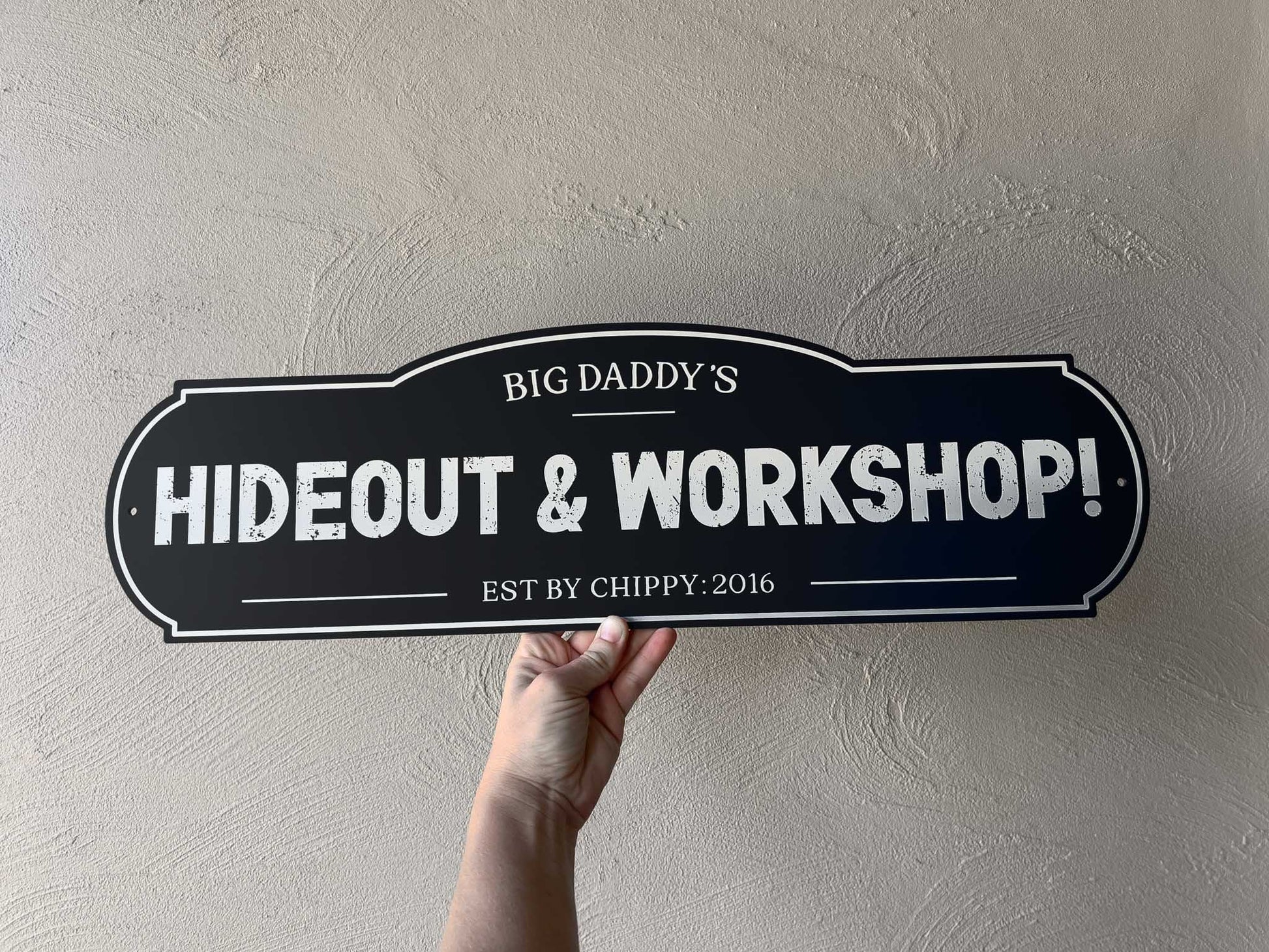 Custom design vintage painted looks sign that says 'Big Daddy's Hideout & Workshop' in black and white.