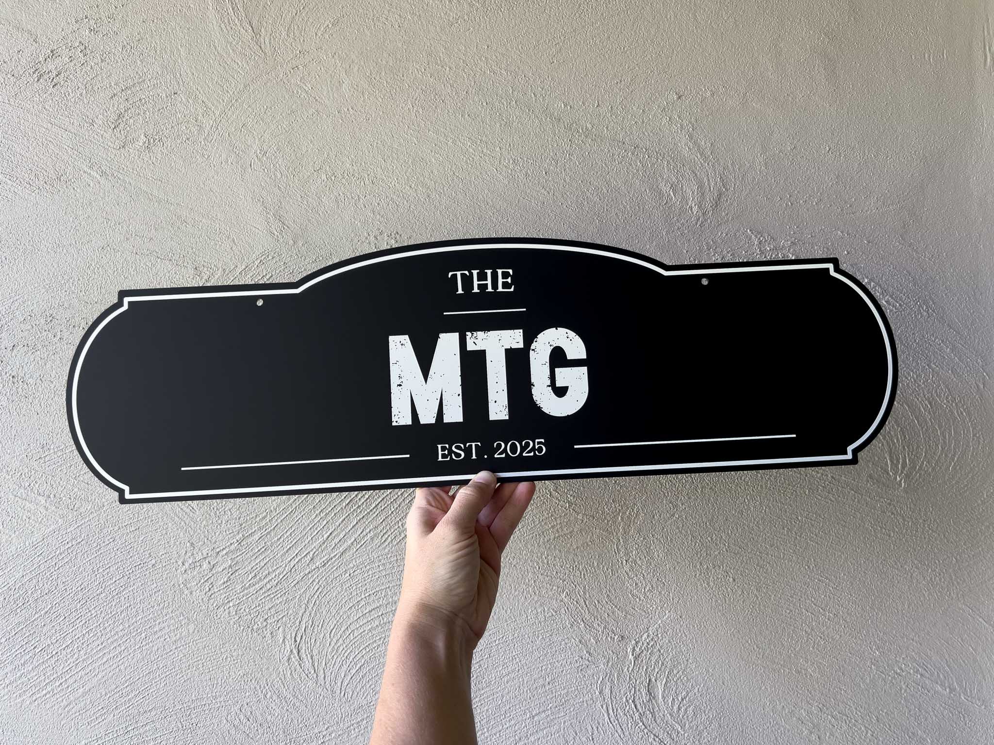 Custom printed vintage arch style sign that reads 'The MTG EST. 2025' in black and white weathered text.
